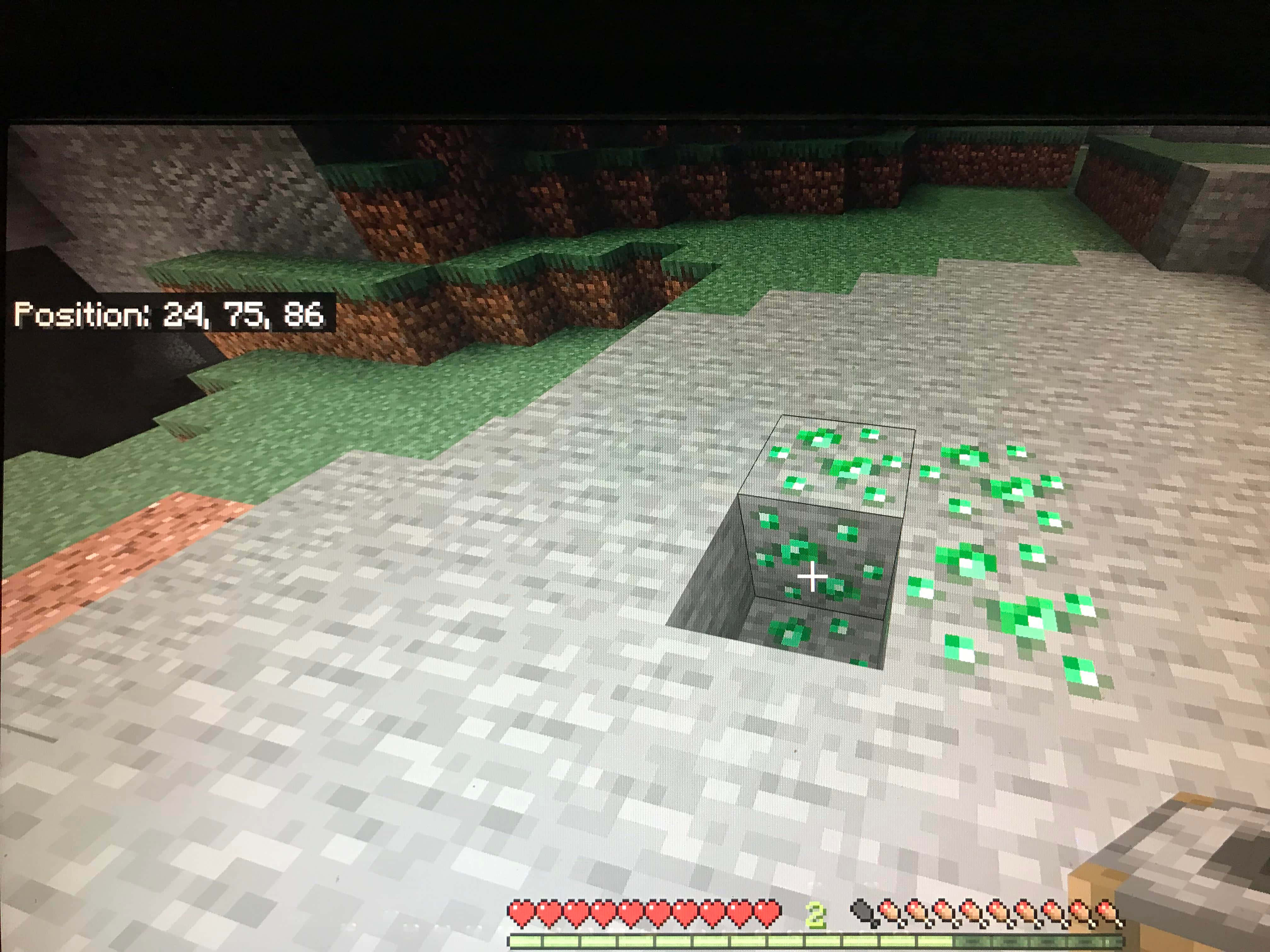 Minecraft Emeralds 桌布 壁紙 — Minecraft 第一人稱視角，顯示從雪地生物群落開採的鑽石礦石方塊，背景有長滿草的懸崖。