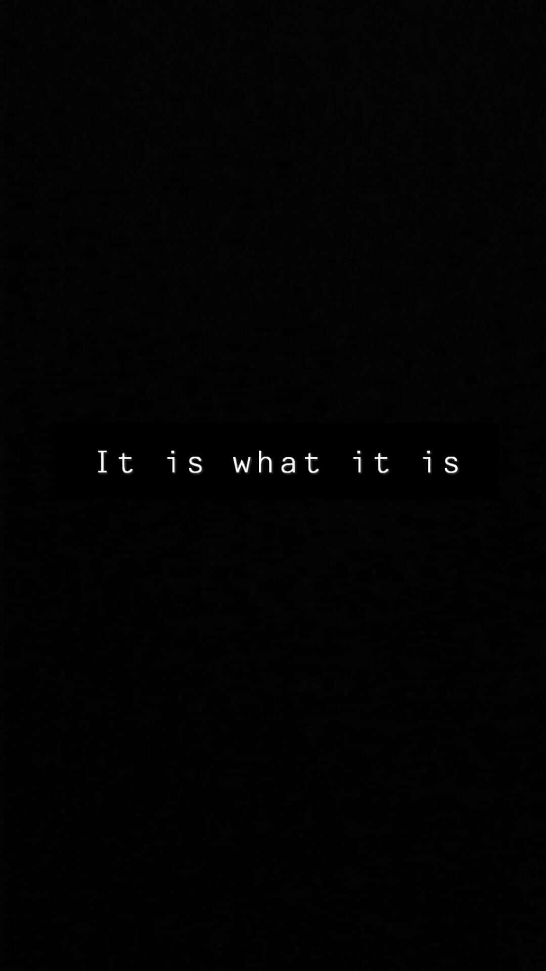  壁紙 — 極簡黑色背景，中央白色文字以乾淨的無襯線字體顯示「It is what it is」。