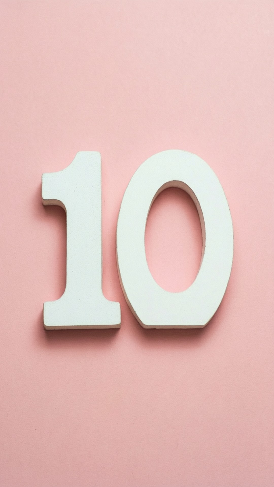 Minimalist Pink 10 壁紙 — 一個白色立體數字十放在柔和的粉紅色背景上，帶有微妙的陰影。