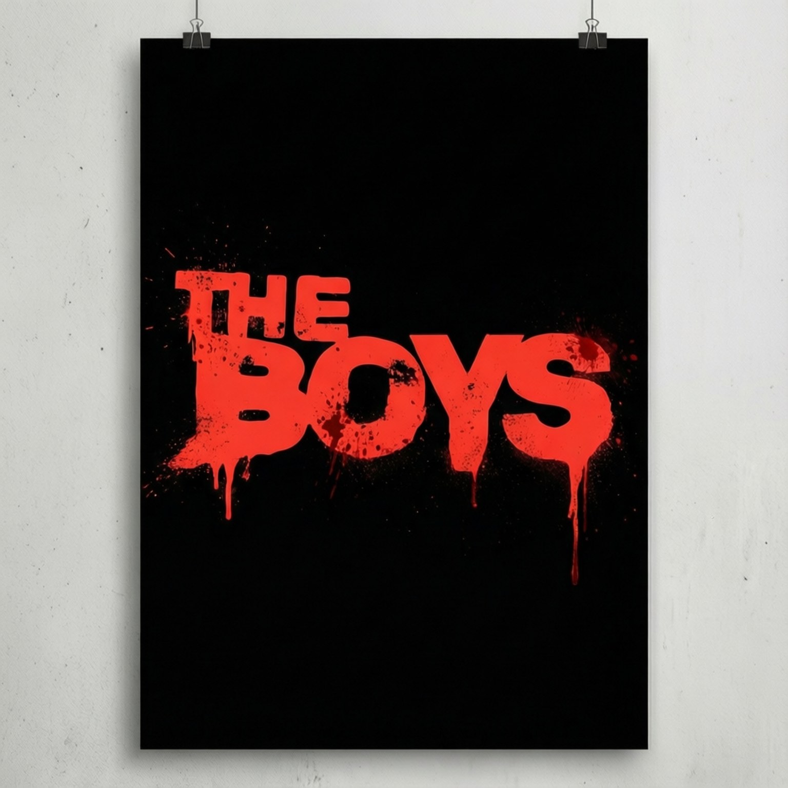 Minimalist Poster 壁紙 — 一張黑色海報，上面有粗體紅色滴落文字寫著「THE BOYS」，用兩個銀色萬字夾夾在白色牆上。