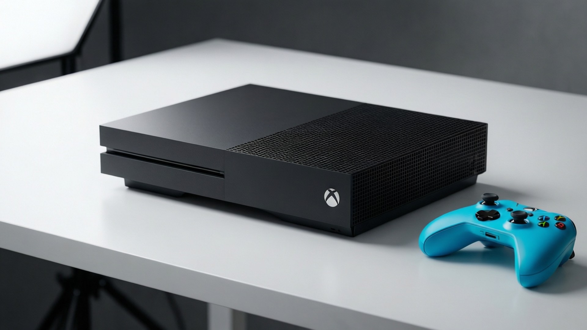 黑色 Xbox One S 主機和青色控制器在白色桌子上，攝影棚環境
