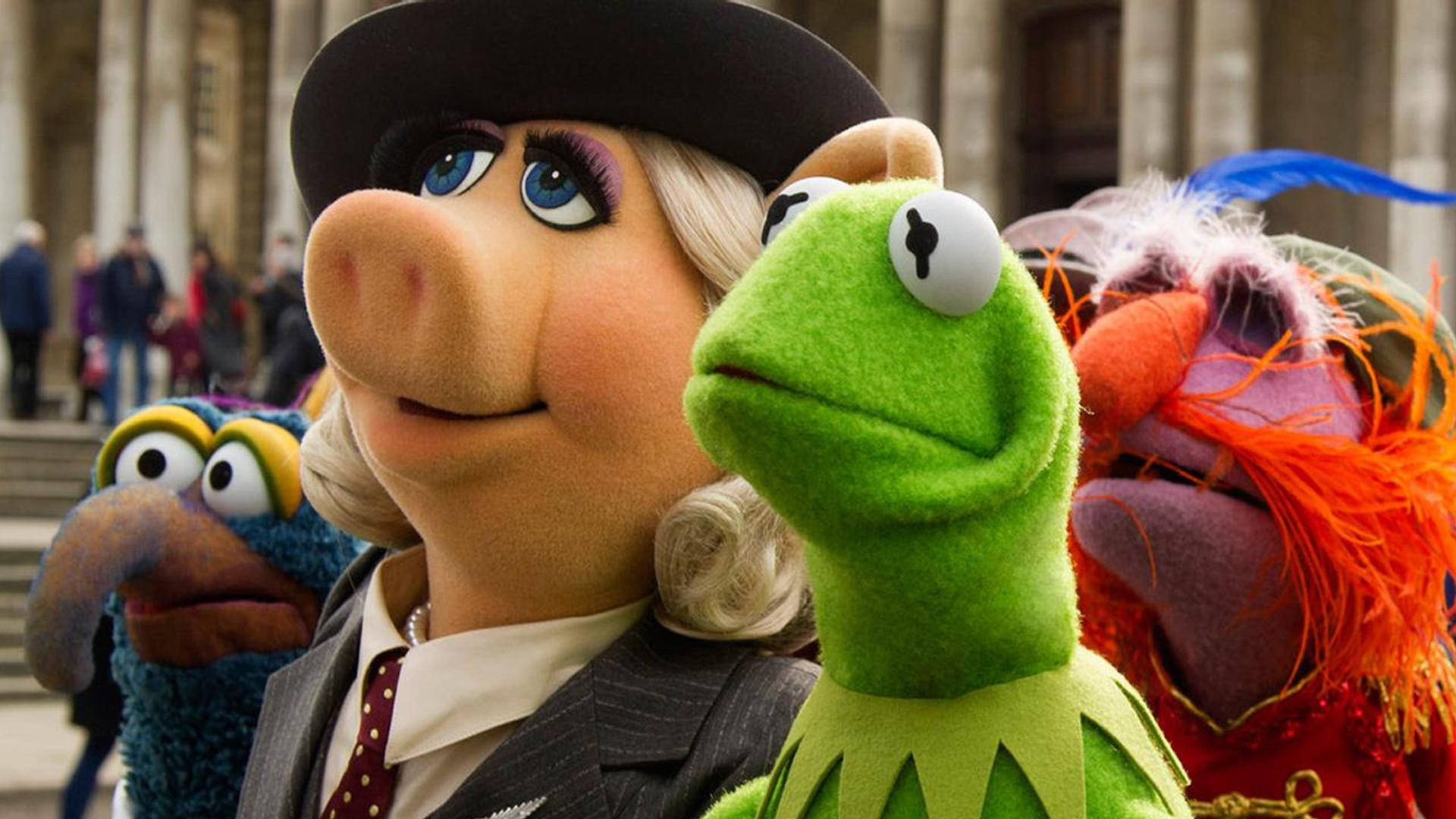 Miss Piggy、Kermit、Animal與Gonzo 壁紙 — 布偶角色穿著正式服裝，在戶外開心地擺姿勢，背景是一座歷史建築。