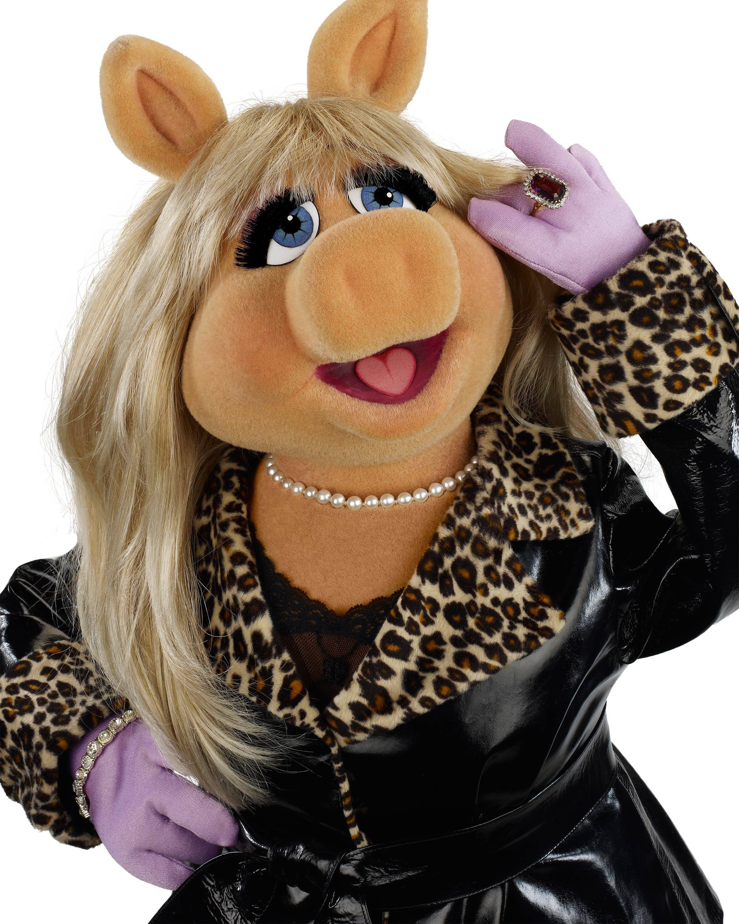 Miss Piggy 穿皮衣 壁紙 — 豬小姐身穿華麗的豹紋外套和紫色手套，在白色背景前自信地擺姿勢。