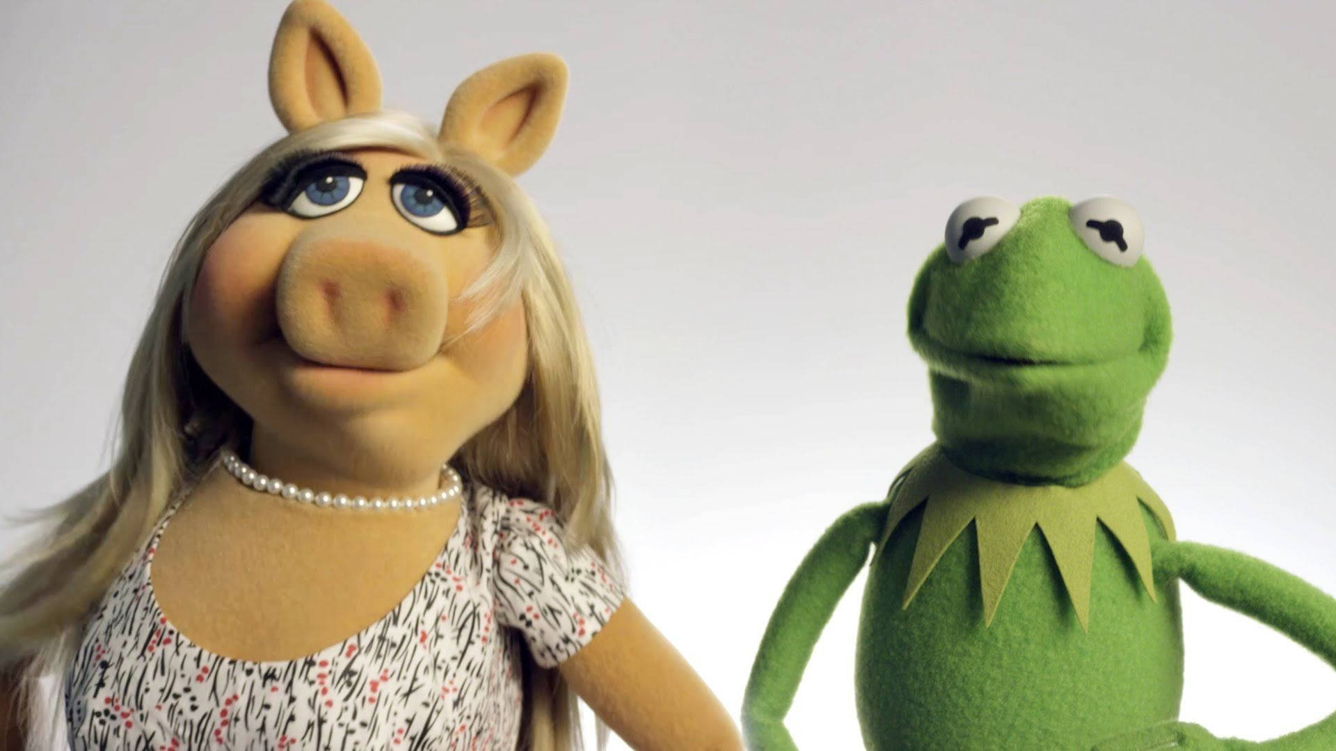 Miss Piggy 與 Kermit 甜蜜拍檔 壁紙 — 豬小姐和青蛙柯密特在明亮的攝影棚燈光下，在純白背景前一起擺姿勢。