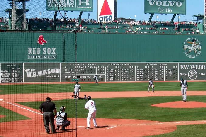 MLB比分：波士頓對坦帕灣 壁紙 — 芬威公園正在進行一場棒球比賽，場上有球員，看台上有球迷，天空清澈湛藍。