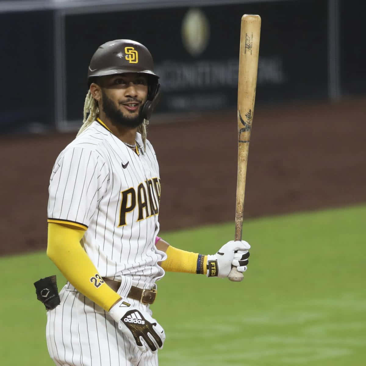穿著教士隊球衣的棒球運動員在夜間場地上握著球棒
