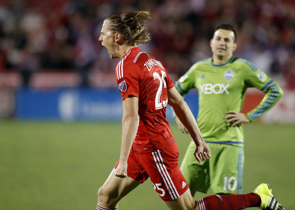MLS 半決賽 韋克·齊默曼 對 馬可·帕帕 壁紙 — 一名身穿紅色球衣的足球員奔跑時頭髮飛揚，身後一名綠色守門員在觀看。