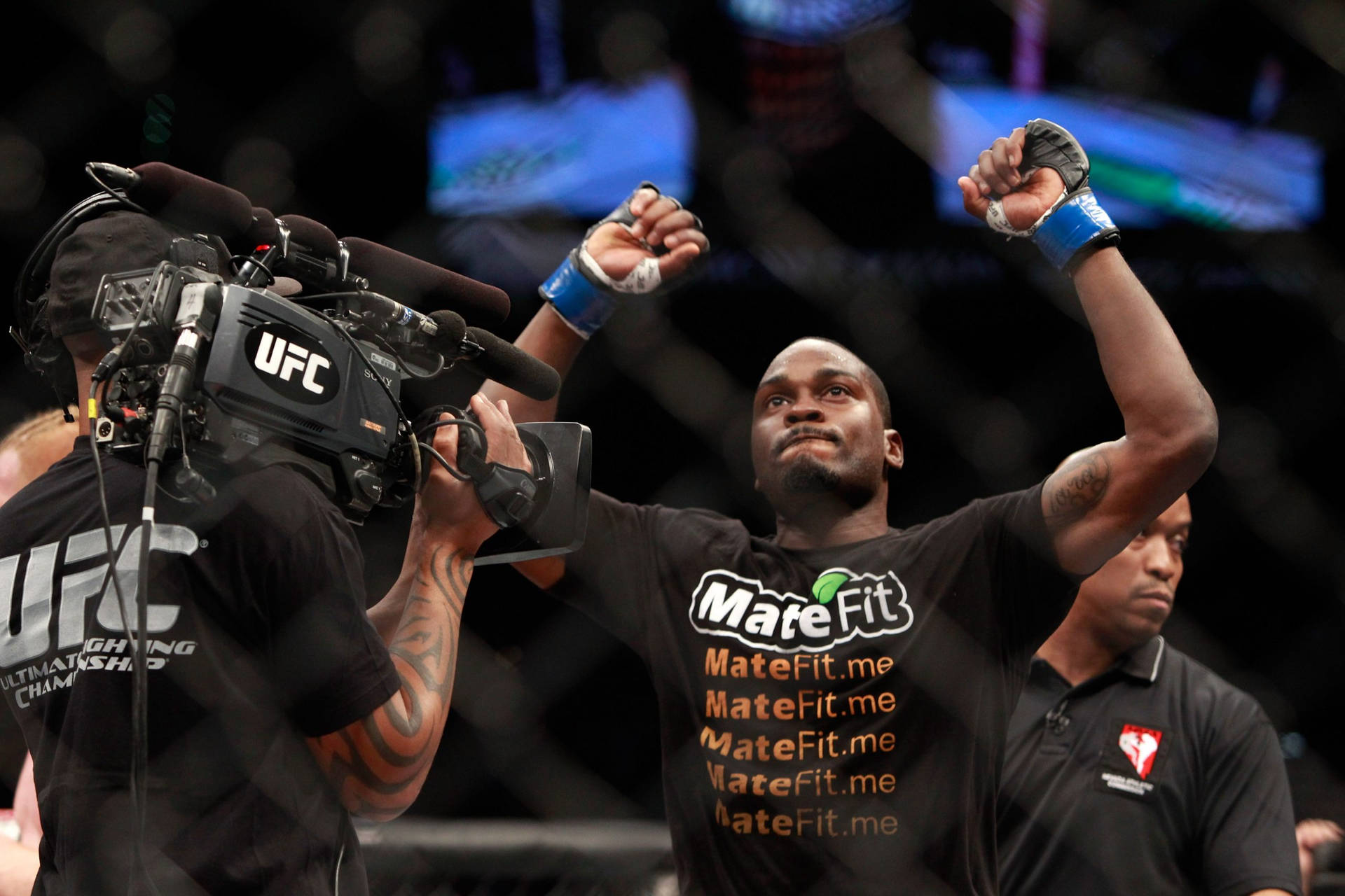 UFC拳手在八角籠內高舉拳頭慶祝勝利。