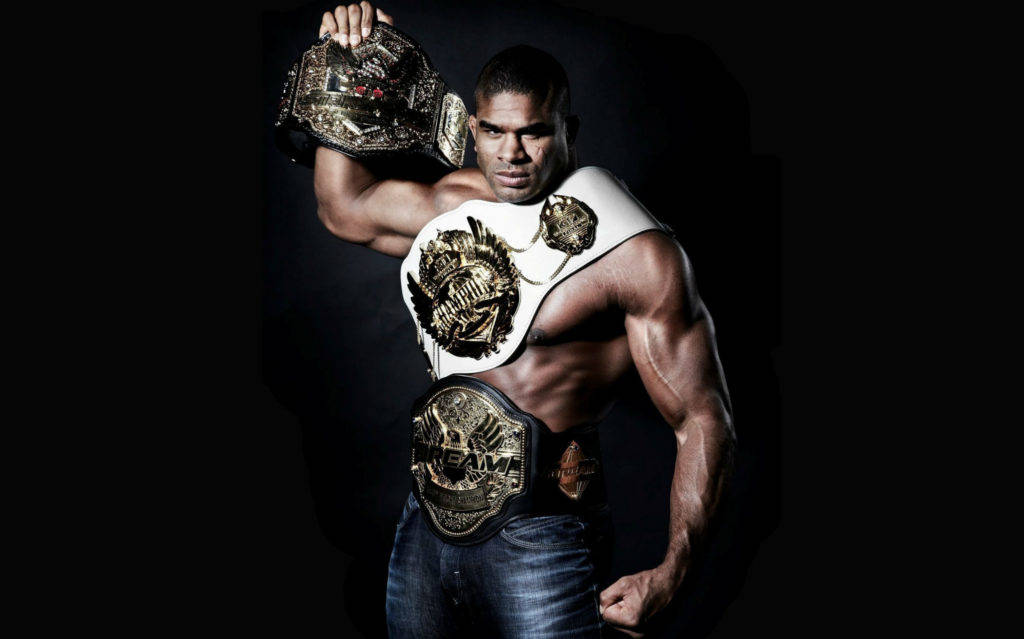 MMA腰帶高清運動壁紙 壁紙 — 一位肌肉發達的摔角手穿著牛仔褲，在黑色背景下自豪地展示多條冠軍腰帶。