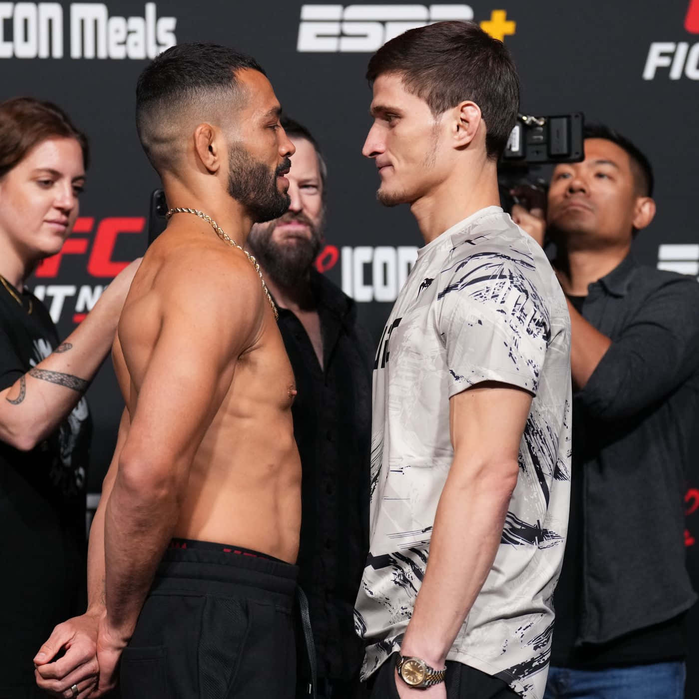 兩名男性MMA拳手在UFC稱重活動中互相凝視。