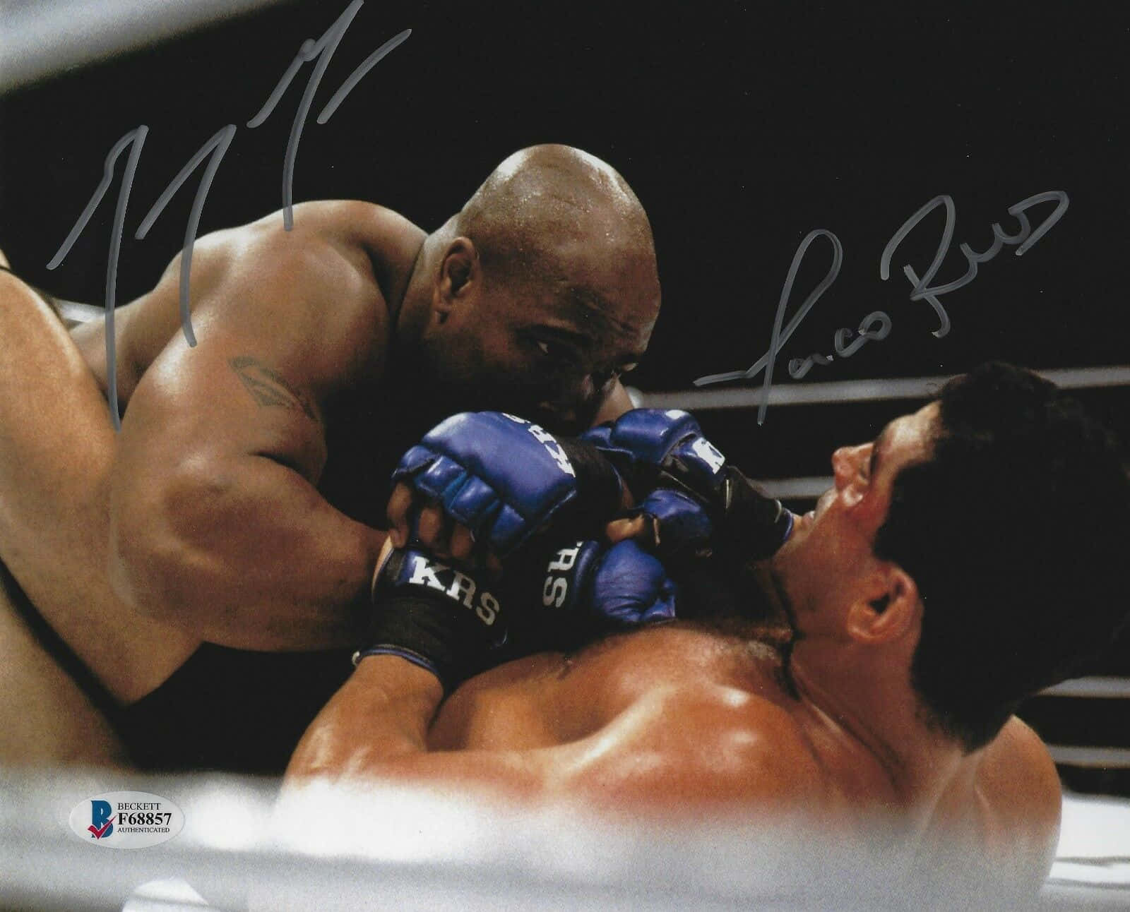 MMA選手加里·古德里奇 壁紙 — 兩名肌肉發達的拳手在燈光昏暗的MMA擂台上激烈纏鬥，可見簽名。