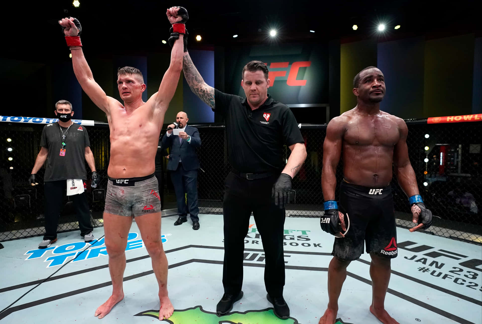 UFC 拳手在八角籠中獲勝，裁判舉起他的手。