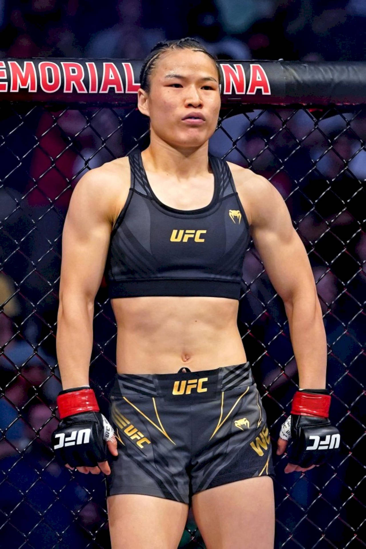 穿著UFC裝備的女性MMA拳手站在八角籠內。