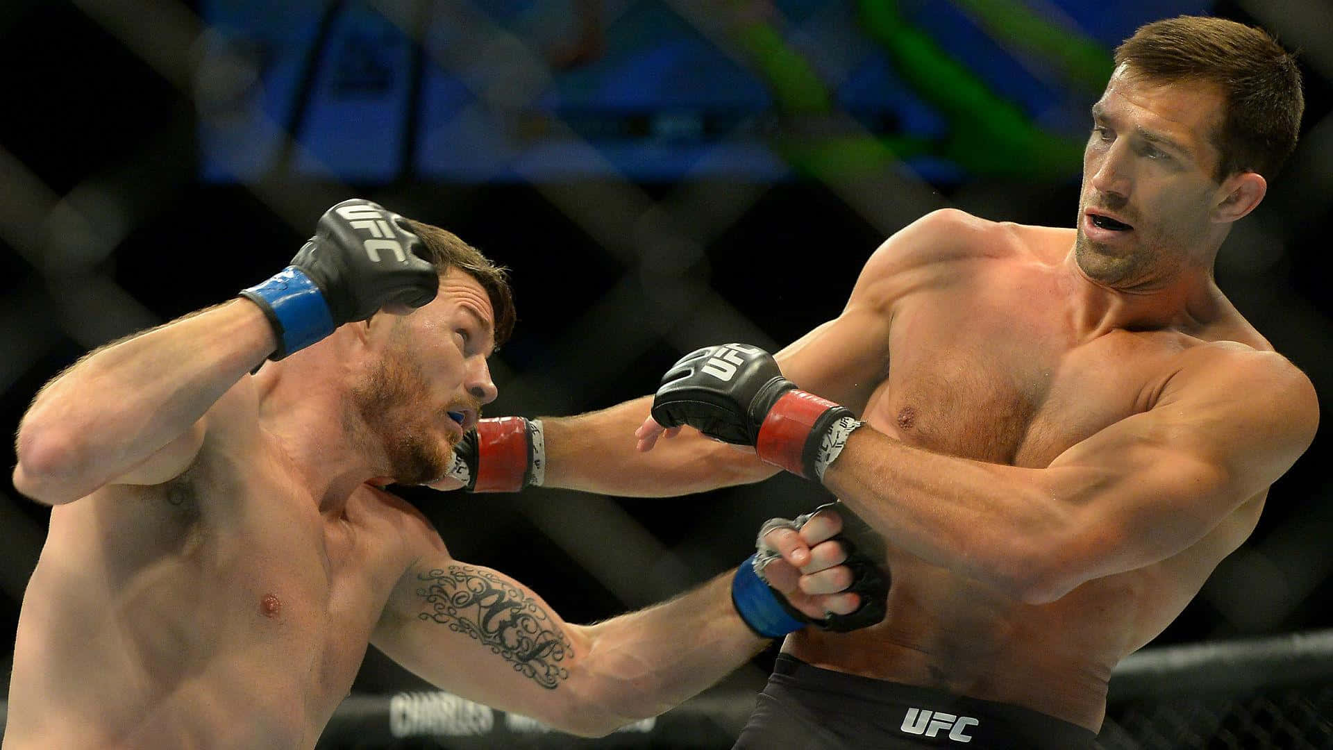 MMA選手盧克·羅克霍德與邁克爾·比斯平UFC 199 壁紙 — 兩名肌肉發達的拳手在UFC八角籠中交鋒，其中一人向對方臉部打出強力一拳。