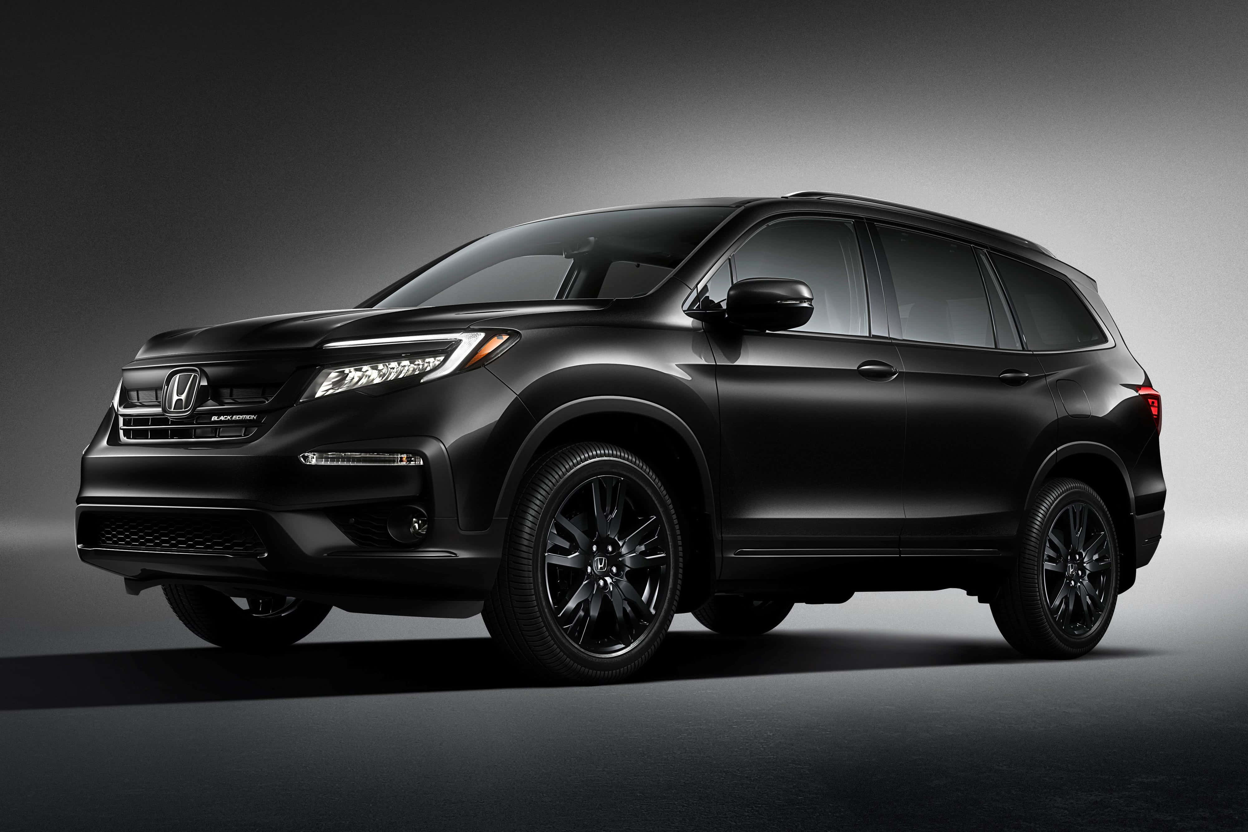 Honda Pilot 桌布 壁紙 — 在工作室中展示的時尚磨砂黑色本田Pilot SUV，配以戲劇性燈光和漸變灰色背景。