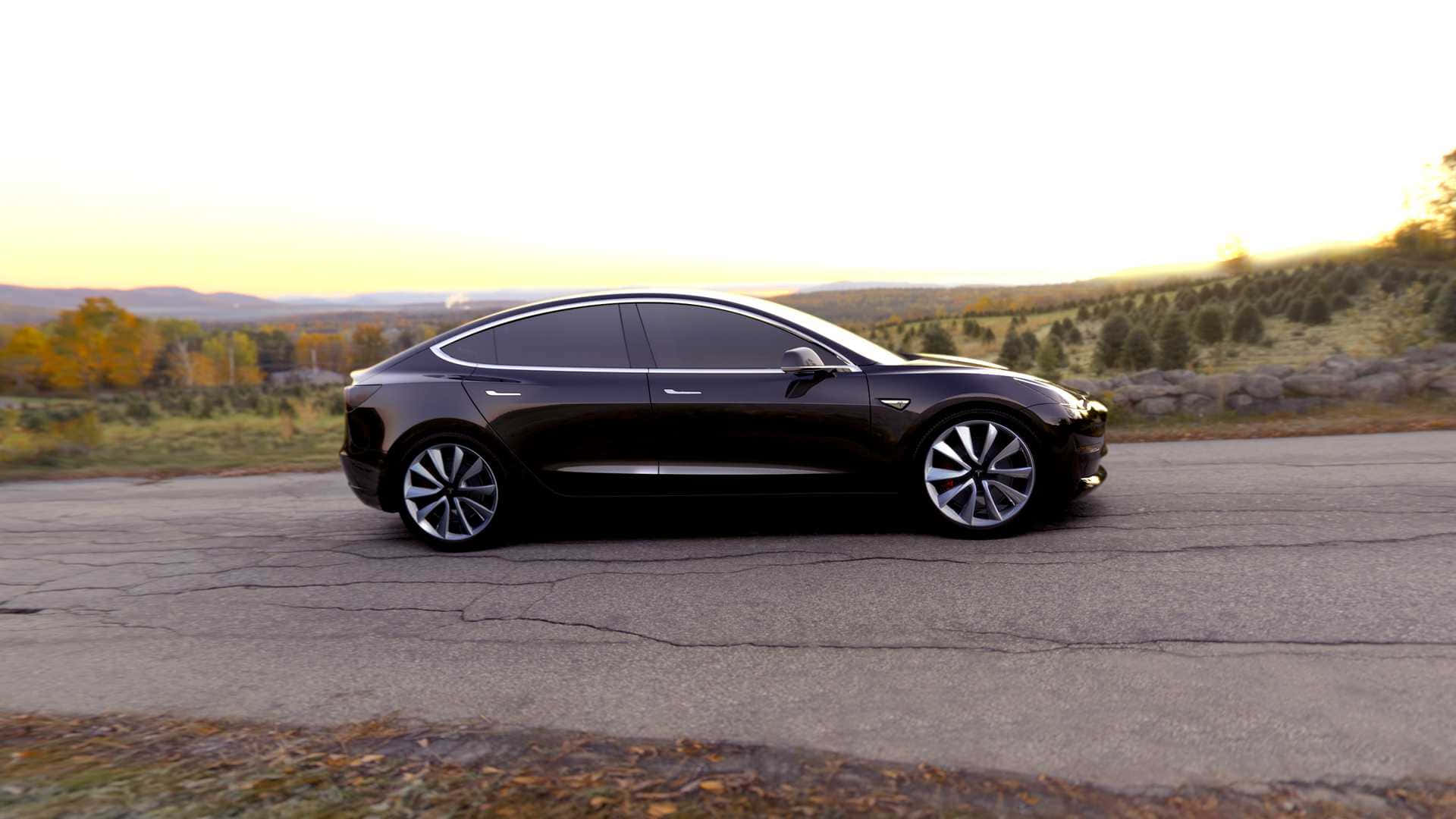 時尚、環保且極致高效的特斯拉 Model 3 壁紙 — 一輛時尚的黑色 Tesla Model 3 停在裂開的瀝青路上，正值黃金時刻，背景有秋樹和起伏的山丘。