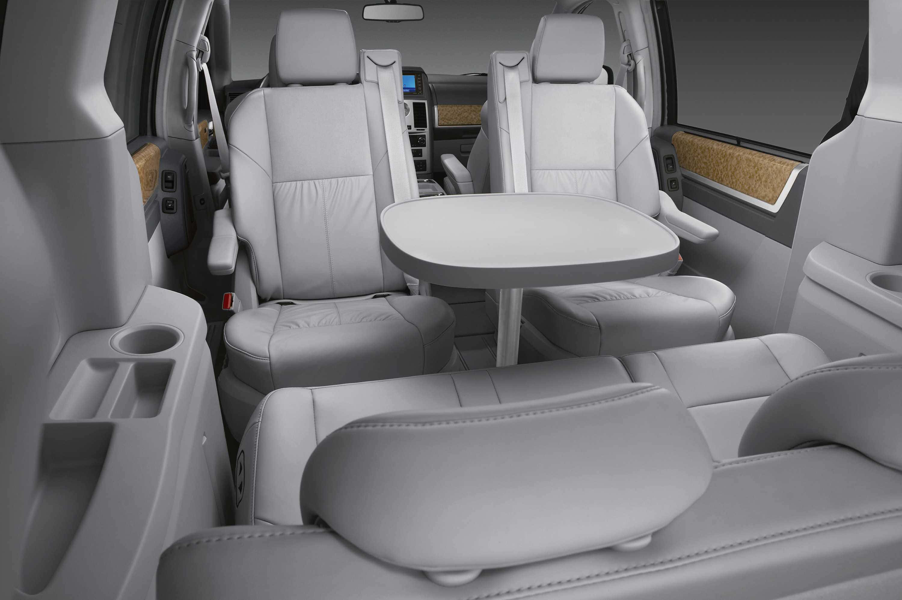 Chrysler Voyager 桌布 壁紙 — 現代小型貨車內部，配有淺灰色皮革座椅和後排乘客用的摺疊桌。