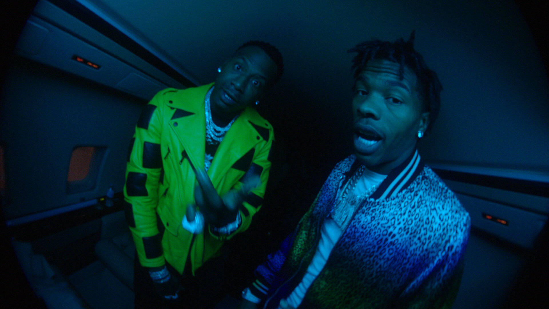 Moneybagg Yo 與 Lil Baby 壁紙 — 兩名身穿鮮豔外套的男子在藍色霓虹燈光下，於昏暗的豪華車內戲劇性地擺姿勢。