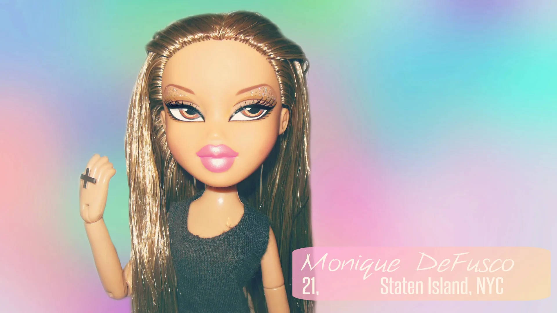 擁有金色長髮和黑色上衣的 Bratz 公仔，在粉彩漸變背景前。