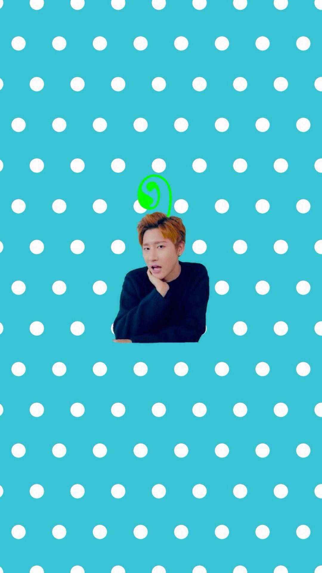 Monsta X Changkyun 波點背景 壁紙 — 一個穿著黑色毛衣的年輕男子，在明亮的藍綠色背景上，有白色圓點和頭頂上的綠色螺旋，手托著下巴。