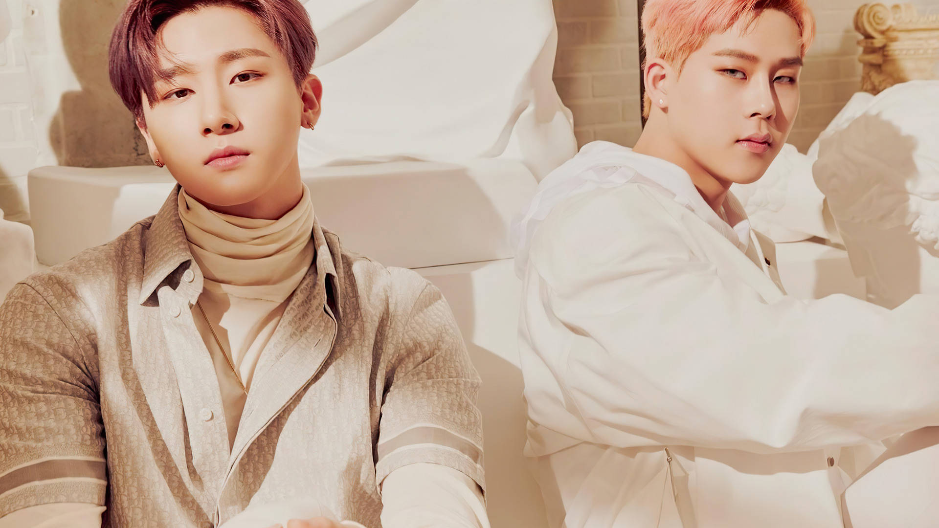 Monsta X Changkyun 與 Joohyeon 壁紙 — 兩位時尚年輕男性在陽光充足的攝影棚中自信擺姿勢，背景有白色雕塑元素和溫暖的金色色調。
