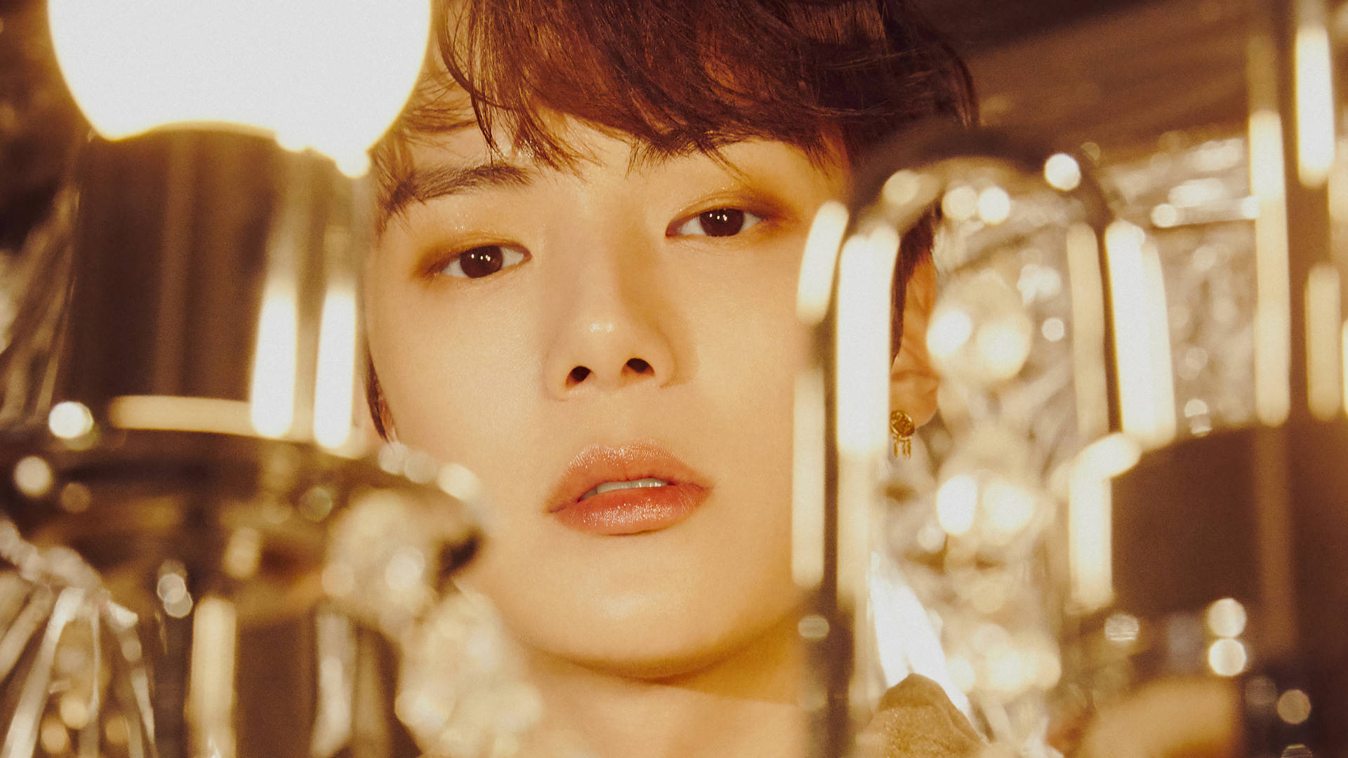Monsta X Minhyuk 路燈造型 壁紙 — 一位年輕男士的特寫肖像，溫暖的燈光與前景的玻璃器皿營造出迷人而親密的氛圍。