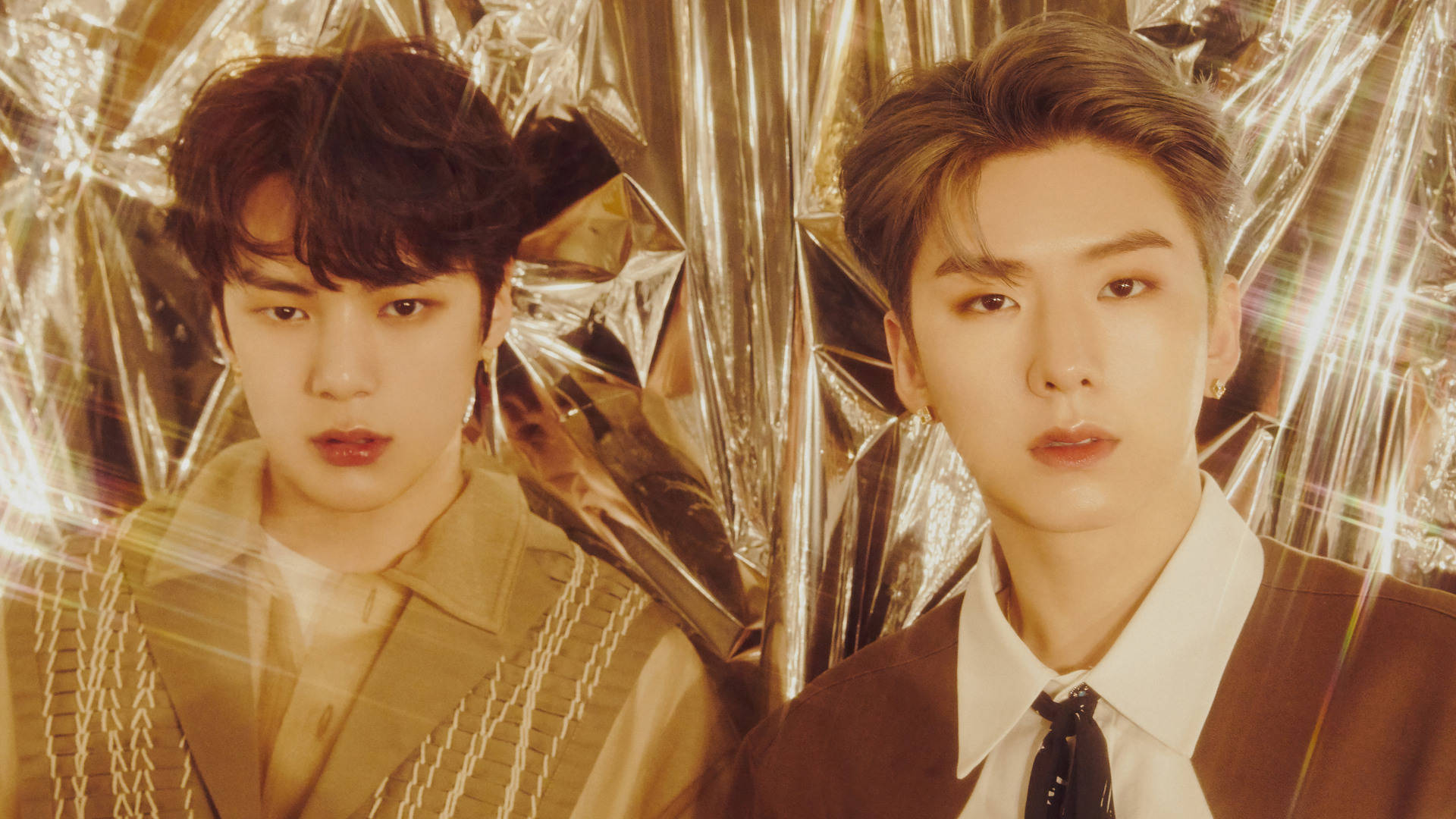 Monsta X Minhyuk 與 Kihyun 壁紙 — 兩位穿著時尚的男士站在閃爍的金箔背景前，伴隨著耀眼的光線。