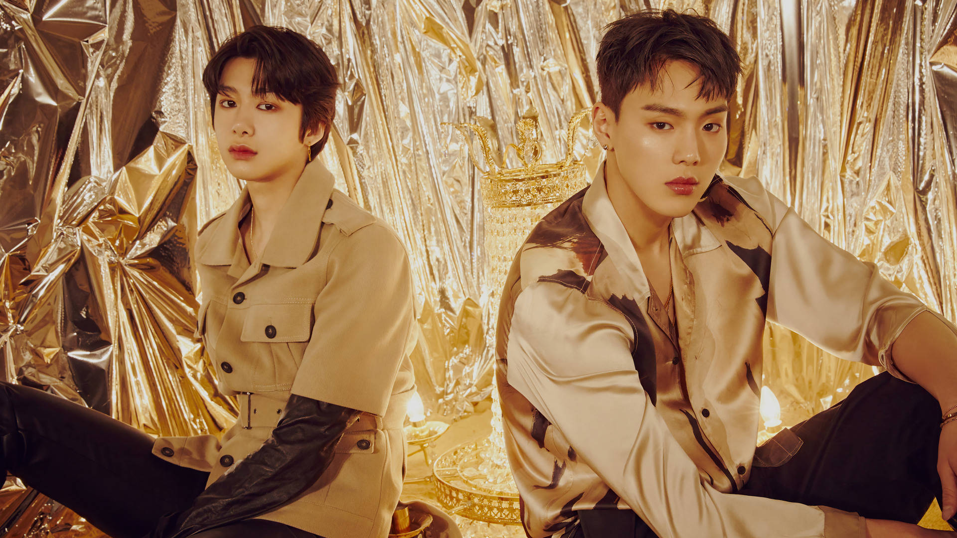 Monsta X Shownu Hyungwon 閃耀 壁紙 — 兩名穿著時尚服裝的男子在閃爍的金箔背景和溫暖燈光下自信地擺姿勢。