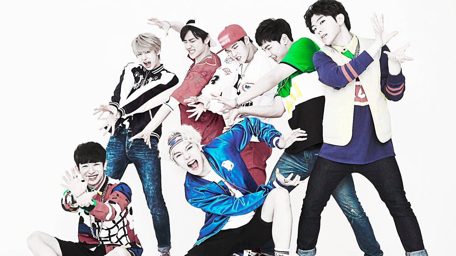Monsta X《Hero》舞台強勢造型 壁紙 — 七位身穿色彩繽紛街頭服的年輕男性，在純白背景前擺出充滿活力的動感姿勢。