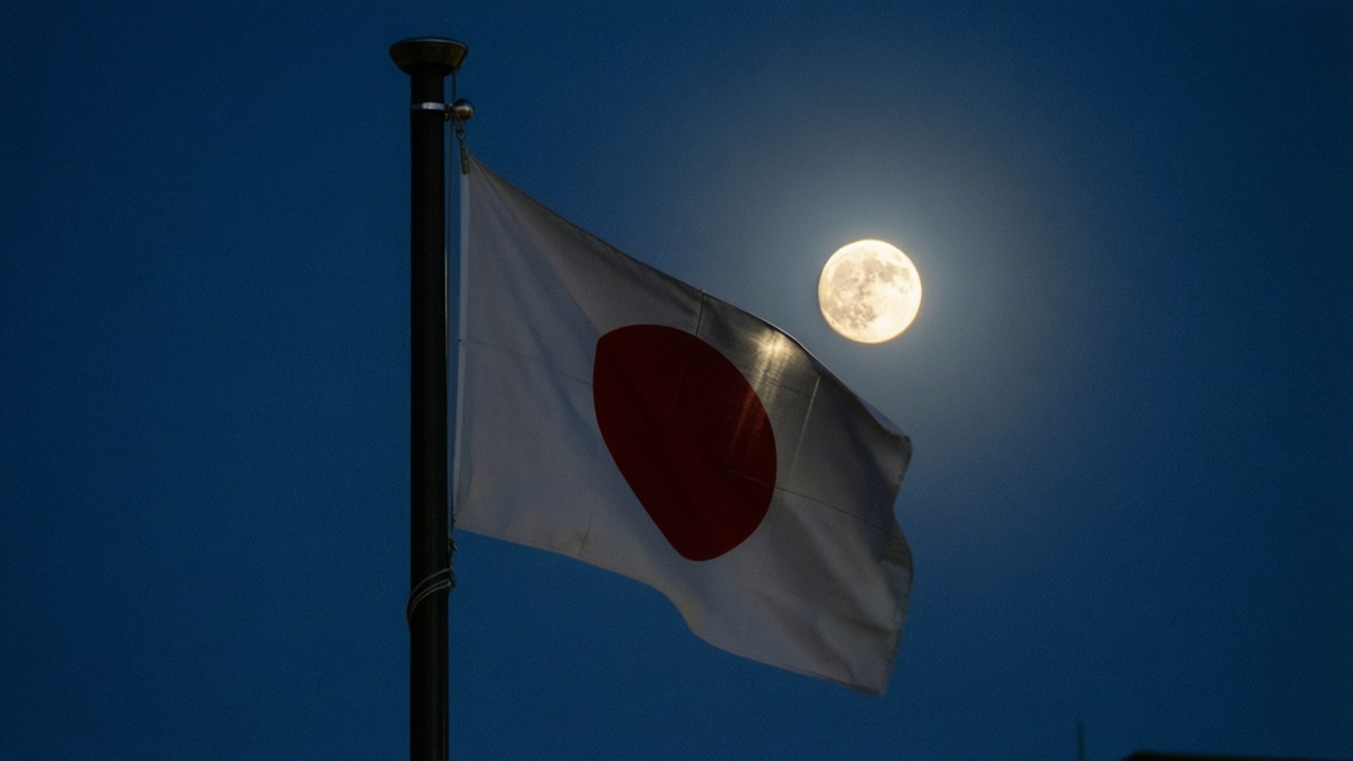 日本國旗在夜風中飄揚，背後有滿月