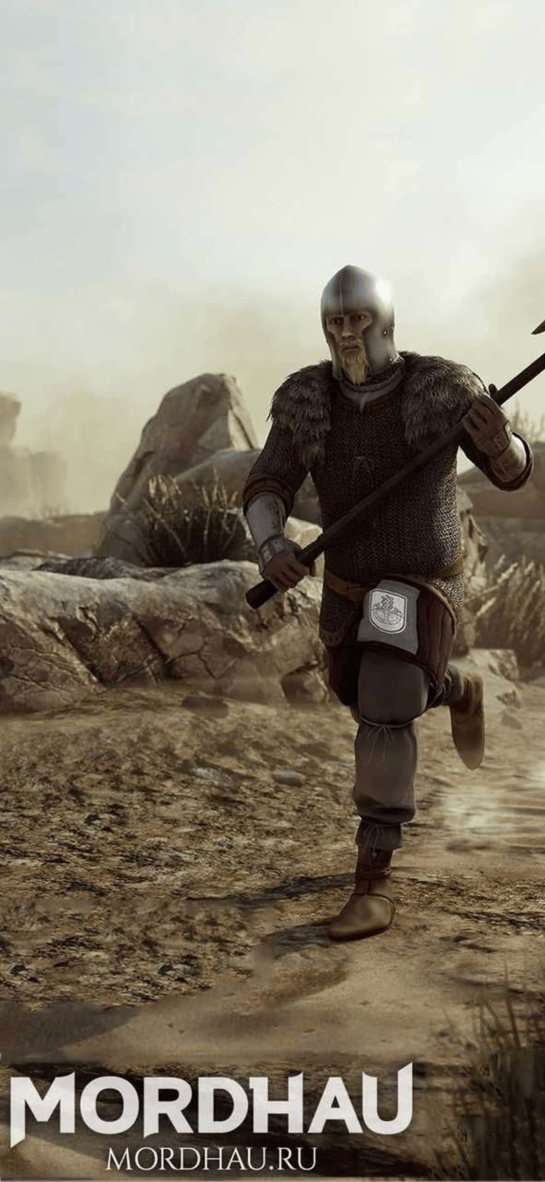 Mordhau 遊戲戰士 iPhone XS 背景設計 壁紙 — 一位身穿鎖子甲和毛皮邊飾鎧甲的中世紀戰士，手持長柄武器，在塵土飛揚的岩石地形上前行。