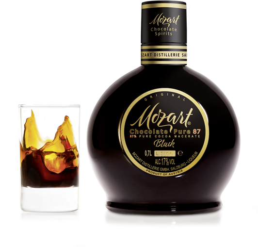 Mozart黑巧克力利口酒瓶 壁紙 — 一支閃亮的Mozart Chocolate Pure 87 Black利口酒瓶立在一個裝有旋轉琥珀色液體的玻璃杯旁，背景是純白色。