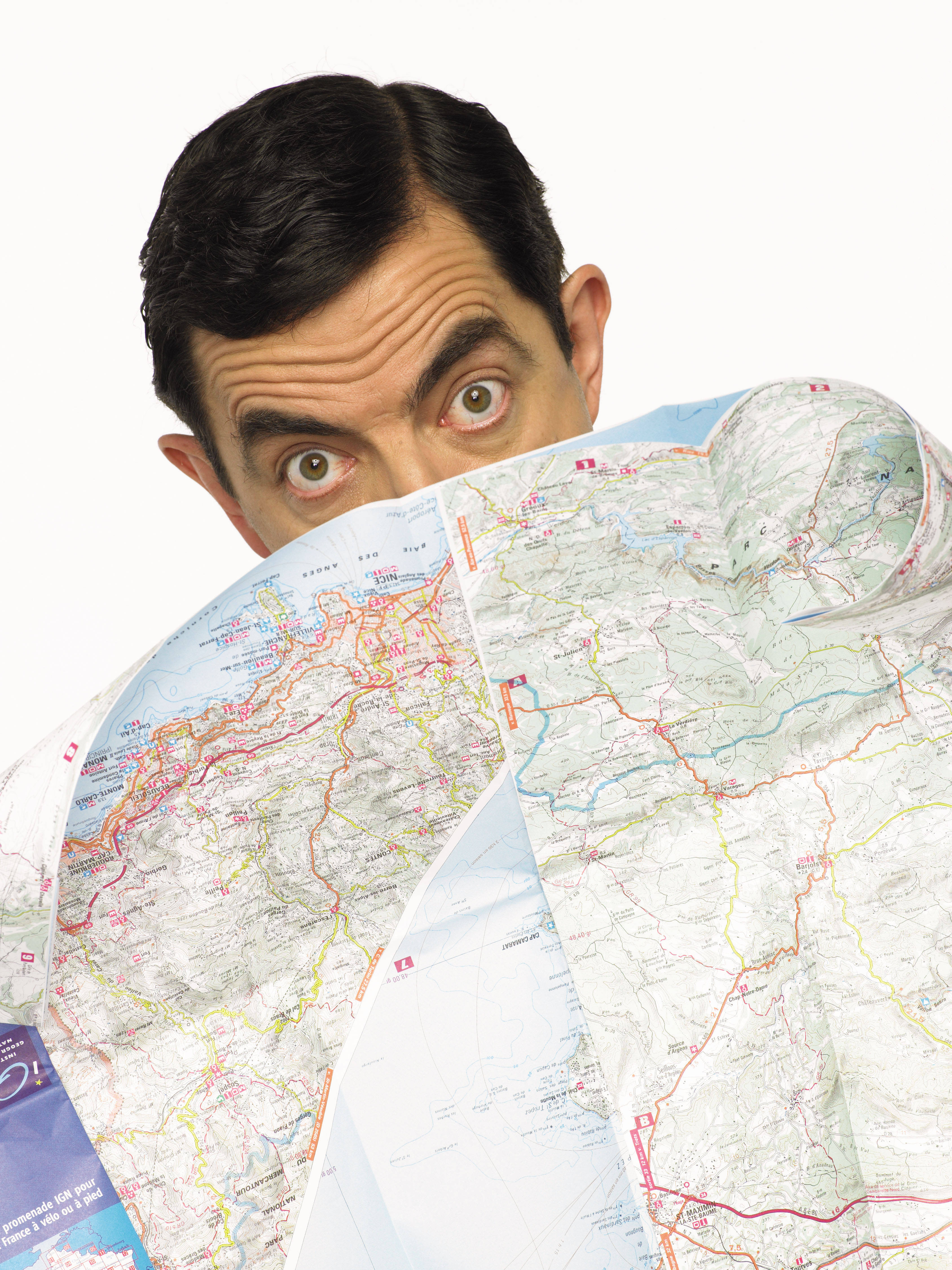 4K 桌布 壁紙 — Mr Bean 喺一張皺巴巴嘅道路地圖上面，對住純白色背景，瞪大眼露出搞笑嘅驚訝表情。