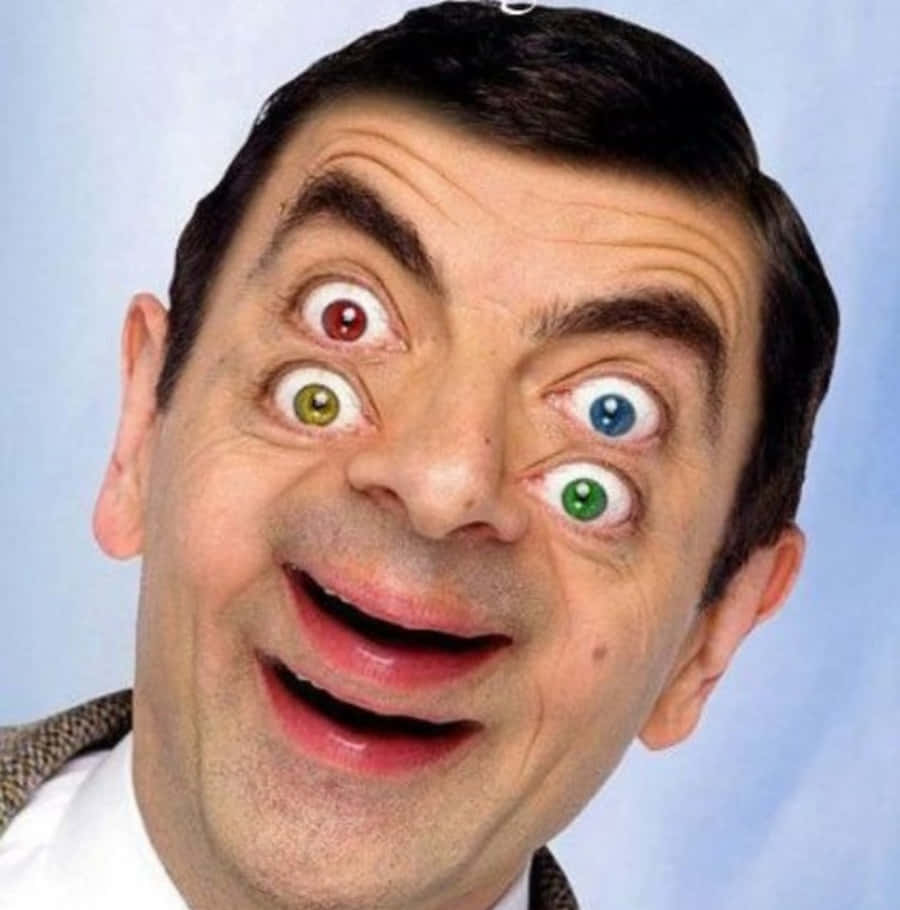 Funny Faces 桌布 壁紙 — Mr Bean 在純藍色背景上，有四隻極不匹配的凸眼和一個狂躁的笑容。