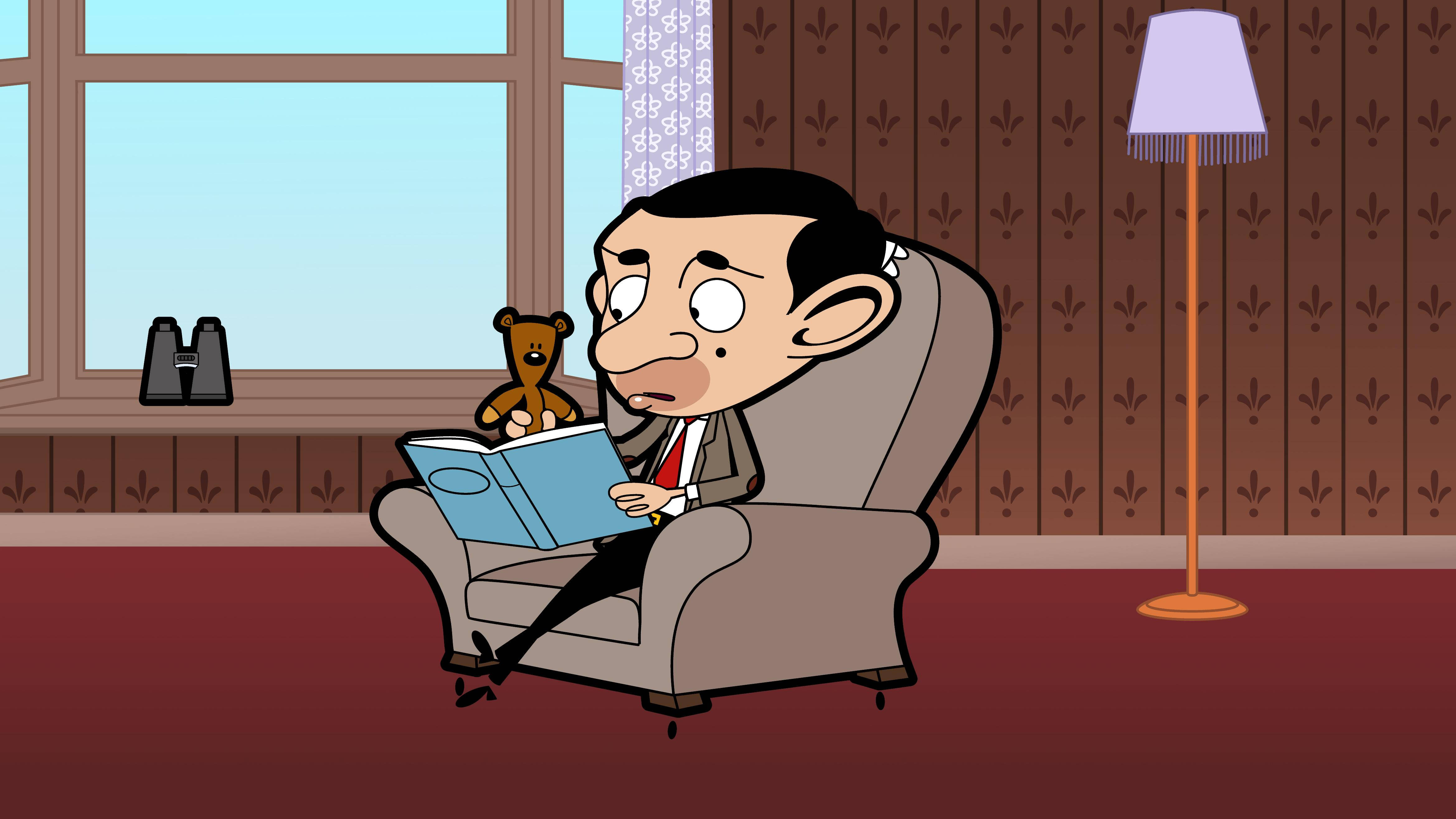 4K 桌布 壁紙 — Mr Bean 坐在一張棕色扶手椅上，讀著一本藍色書，旁邊有一隻泰迪熊，房間貼有圖案牆紙。