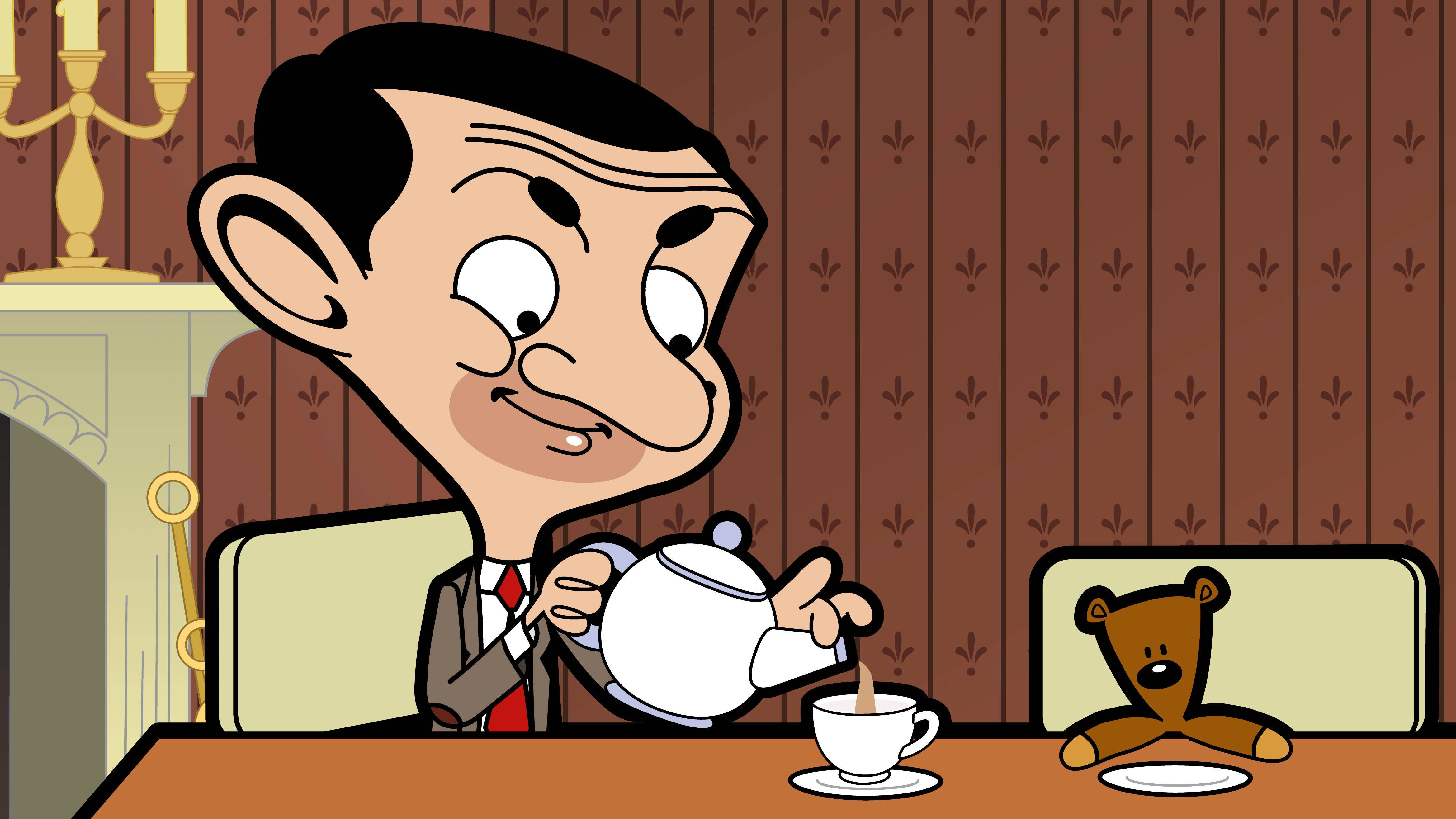4K 桌布 壁紙 — Mr Bean 露出狡黠的笑容倒茶，一隻泰迪熊在木桌旁看著他。