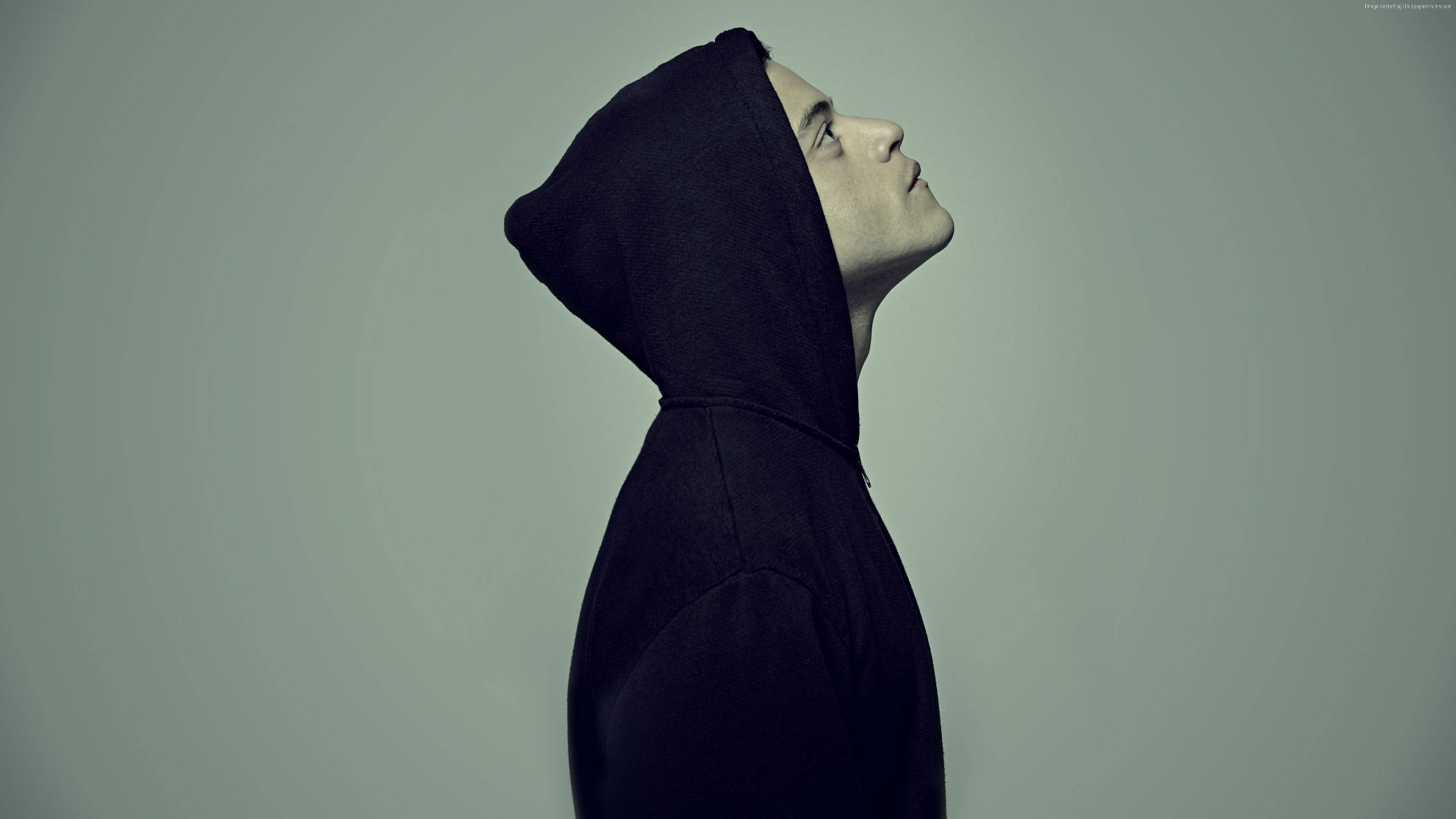 Mr. Robot 艾略特綠色背景漸層 壁紙 — 一個穿著黑色連帽衫的人側面向上凝視，背景為柔和的灰色。
