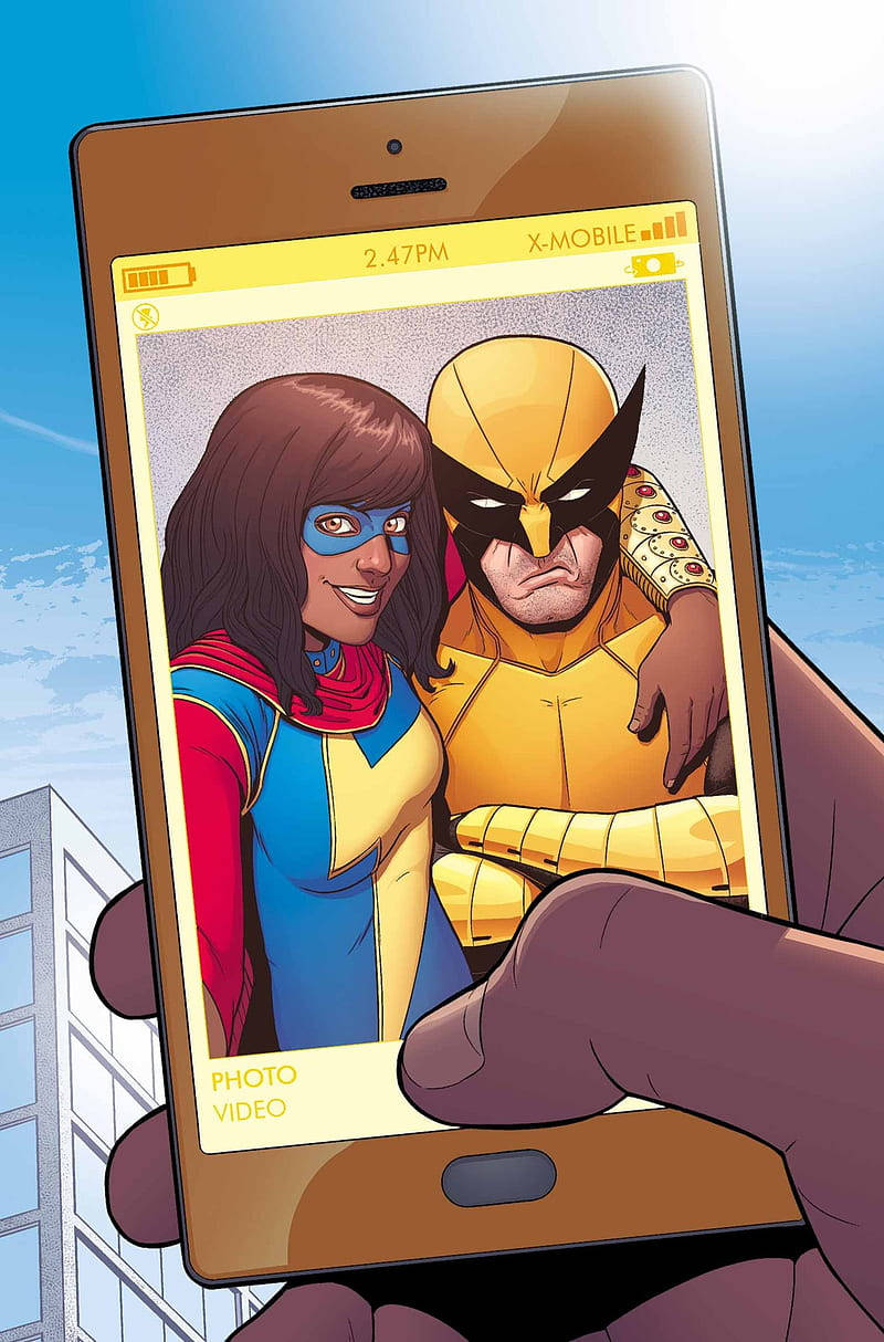 Ms Marvel 與 狼人自拍 壁紙 — 一隻手拿著智能手機，顯示一張漫畫風格的照片，照片中有一位微笑的女子穿著藍黃色服裝，還有一位嚴肅的黃色面具男子，背景是城市景觀。
