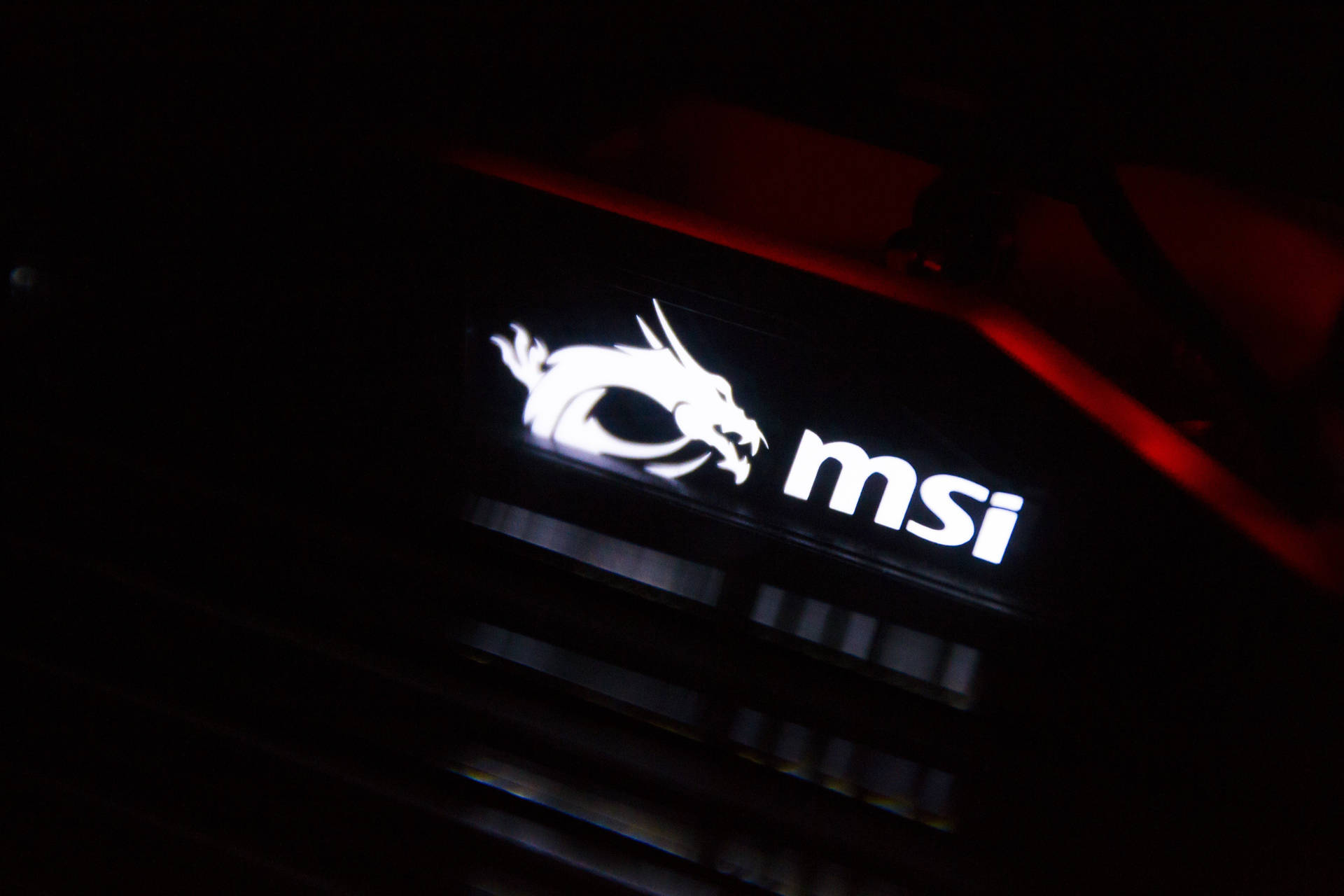 暗色遊戲電腦機箱上帶有紅色燈光的發光MSI龍標誌。