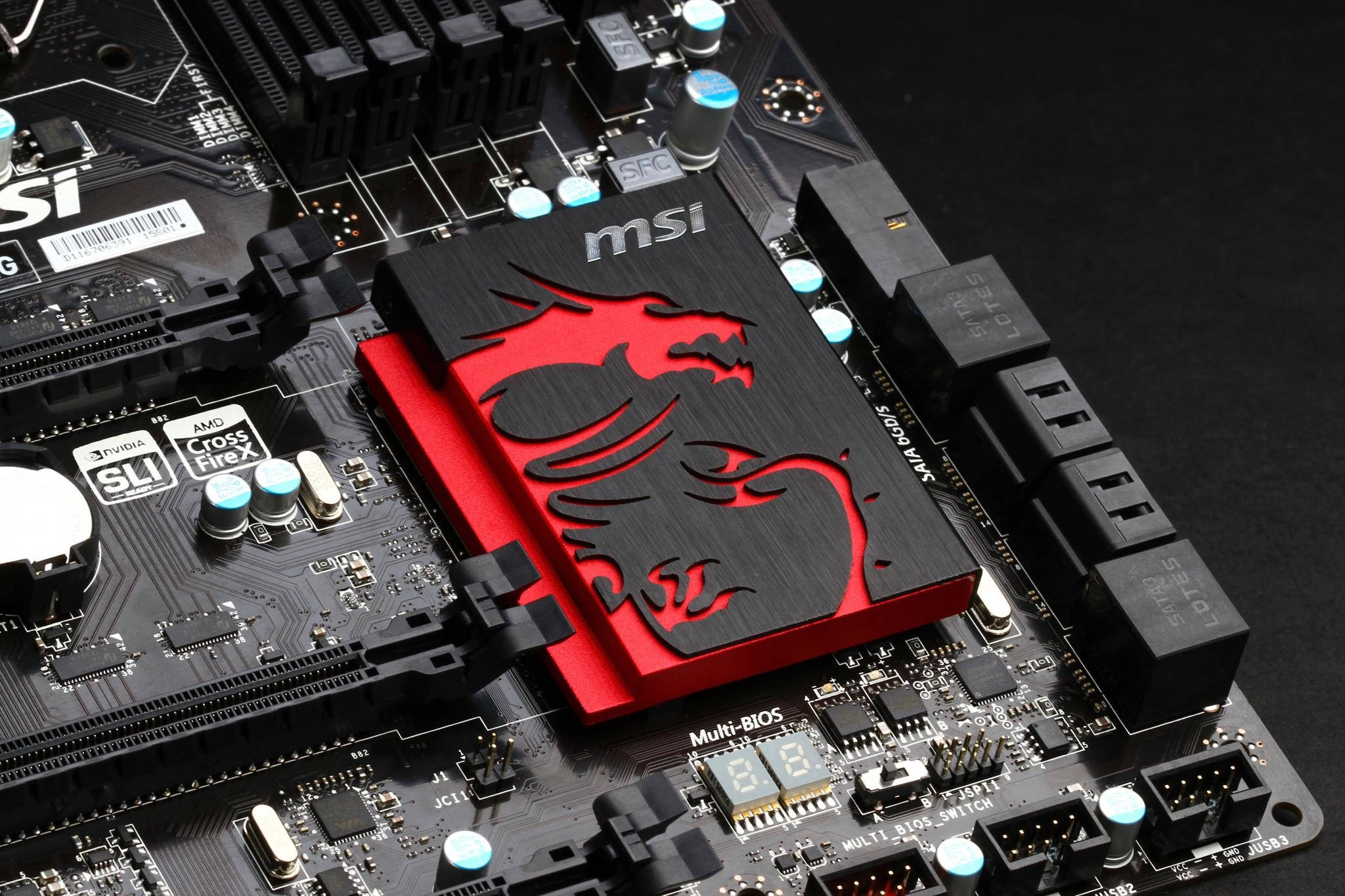 MSI遊戲筆電主機板 壁紙 — 黑色MSI主機板特寫，帶有紅色龍標誌散熱器和發光藍色電容。