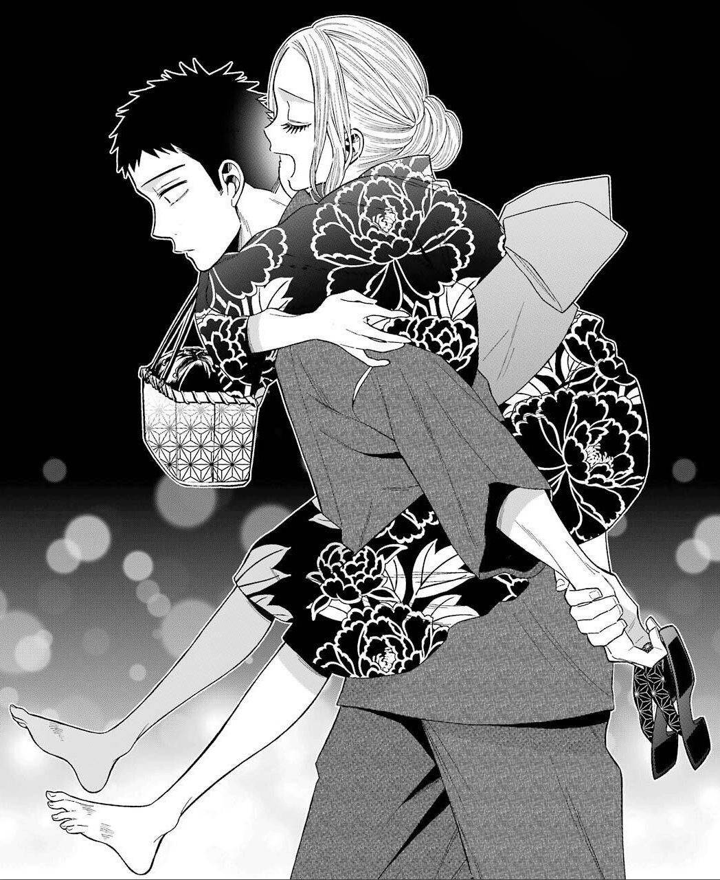 一位穿著花卉和服的女性在柔和的散景背景中抱著一個男人。
