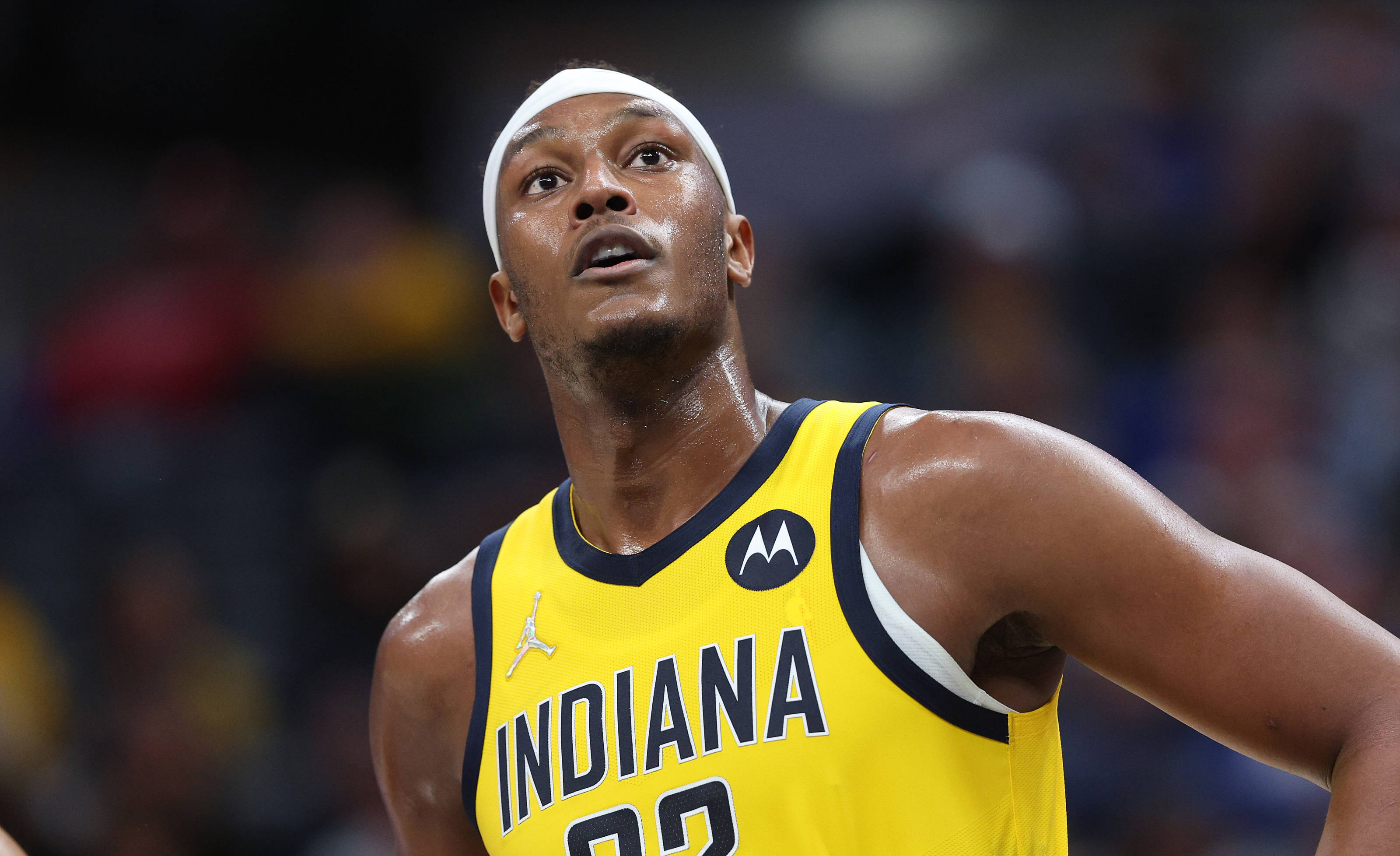 Myles Turner NBA 印第安納戰袍 壁紙 — 一名專注的籃球運動員身穿黃色印第安納球衣，在明亮的場館燈光下於激烈的比賽中向上看。
