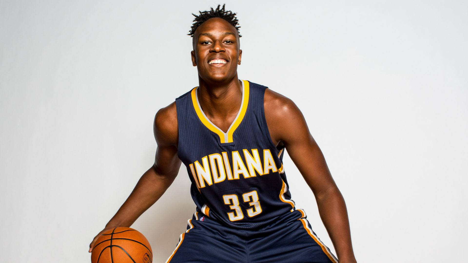 Myles Turner 印第安納新人時期拍攝照 壁紙 — 一名微笑的籃球運動員身穿印第安納球衣，在純白背景前持球。