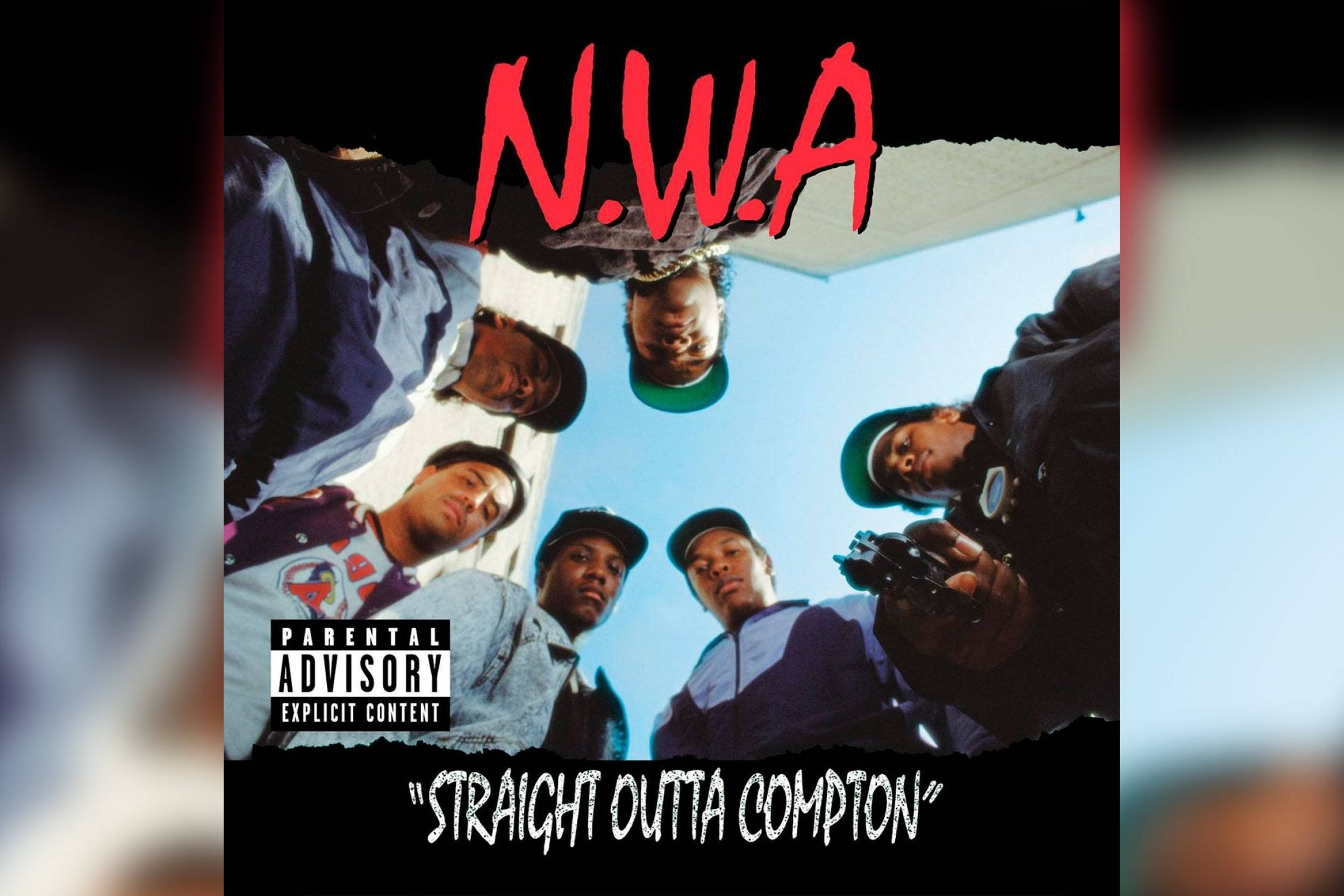N.W.A.《Straight Outta Compton》專輯封面 壁紙 — 五個戴帽嘅男人喺藍天背景下由上向下望，帶有紅色N.W.A文字同家長指引標籤。