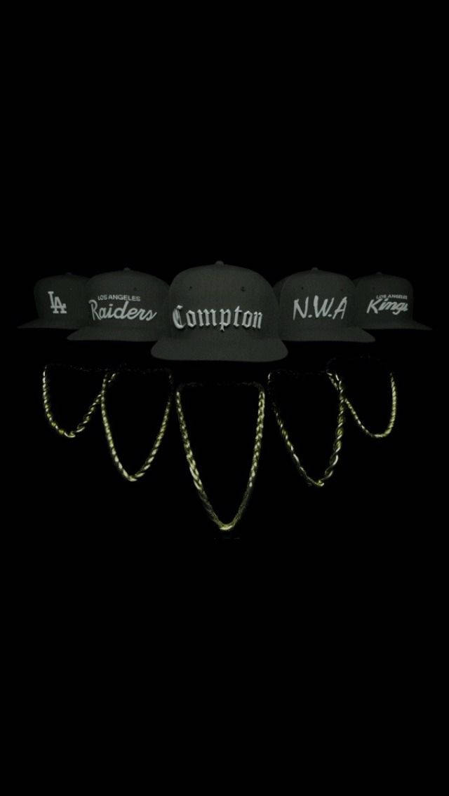 N.W.A. 標誌性服飾與配飾宣傳壁紙 壁紙 — 五頂深綠色 snapback 帽子，帶有 LA 運動和嘻哈標誌，在黑色背景下發光，下方有反光金色鏈條。