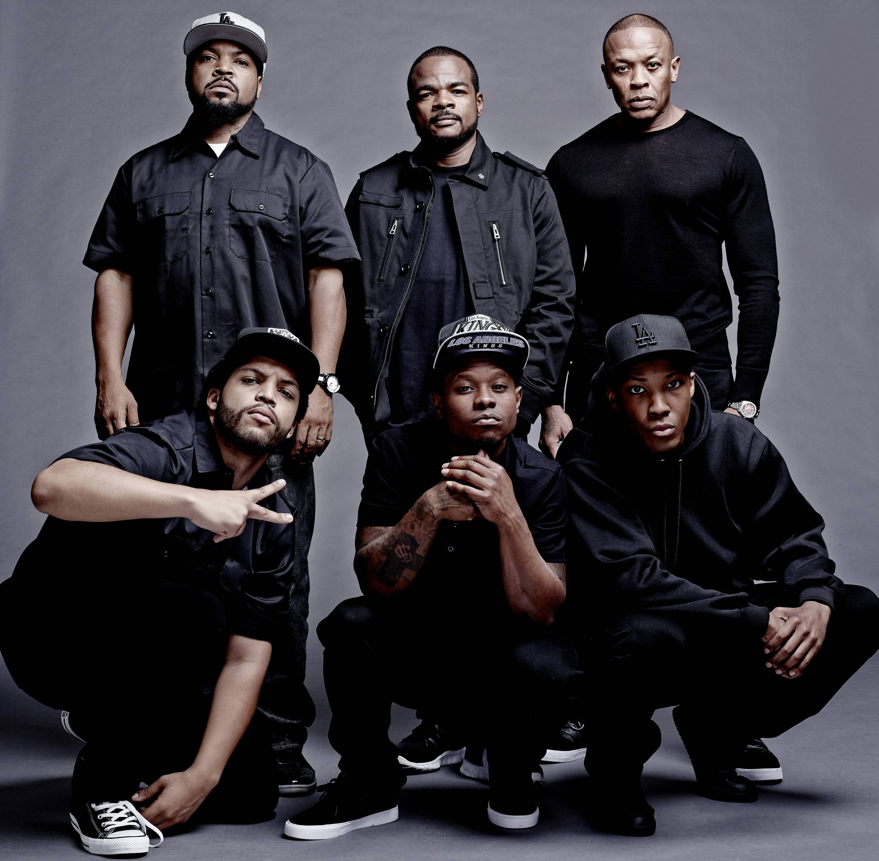 N.W.A.電影《Straight Outta Compton》演員陣容 壁紙 — 六名身穿黑色街頭服飾的男子在灰色工作室背景前自信地擺出嚴肅的表情。