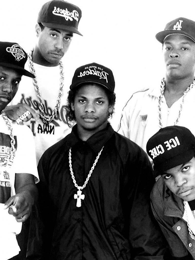 N.W.A.電影《世界最危險樂團》黑白壁紙 壁紙 — 五個戴帽子和鏈條的年輕男子在純白背景前以經典黑白肖像照風格強烈擺姿勢。