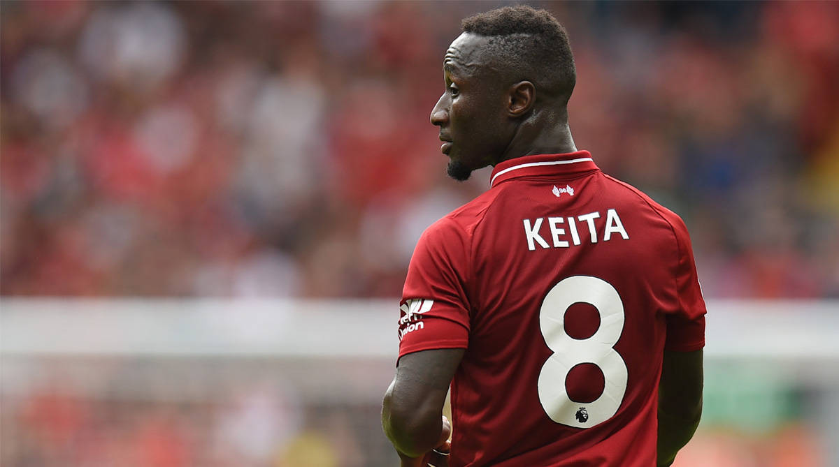Naby Keita 場上精彩表現 壁紙 — 一名身穿紅色球衣、印有Keita名字和8號的足球員站在球場上，背景是模糊的體育場人群。