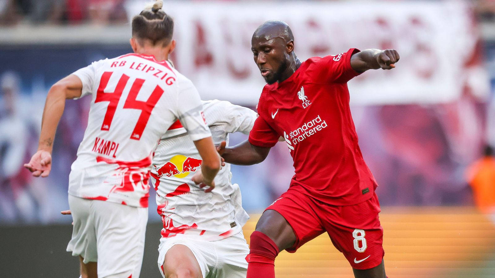 Naby Keita 被包圍 壁紙 — 一位身穿紅色8號球衣的利物浦足球員與身穿44號的RB萊比錫球員爭奪皮球。