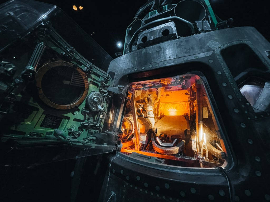 NASA休士頓太空中心技術模型展示 壁紙 — 太空船打開的艙門揭示了在黑暗太空虛空中溫暖照亮的內部。